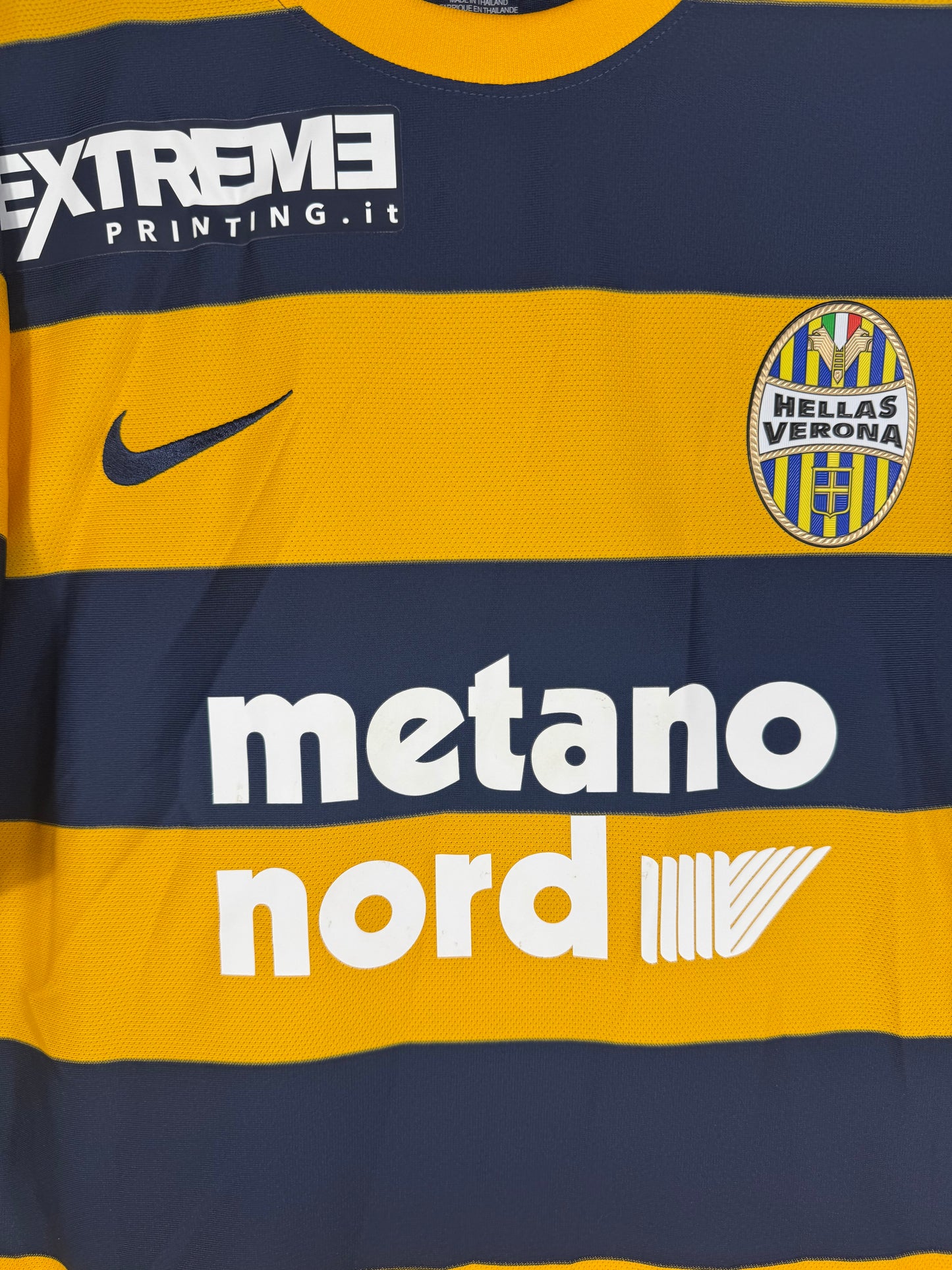 Gros plan sur l'écusson avec les dogues et l'échelle, logo Nike et sponsor.