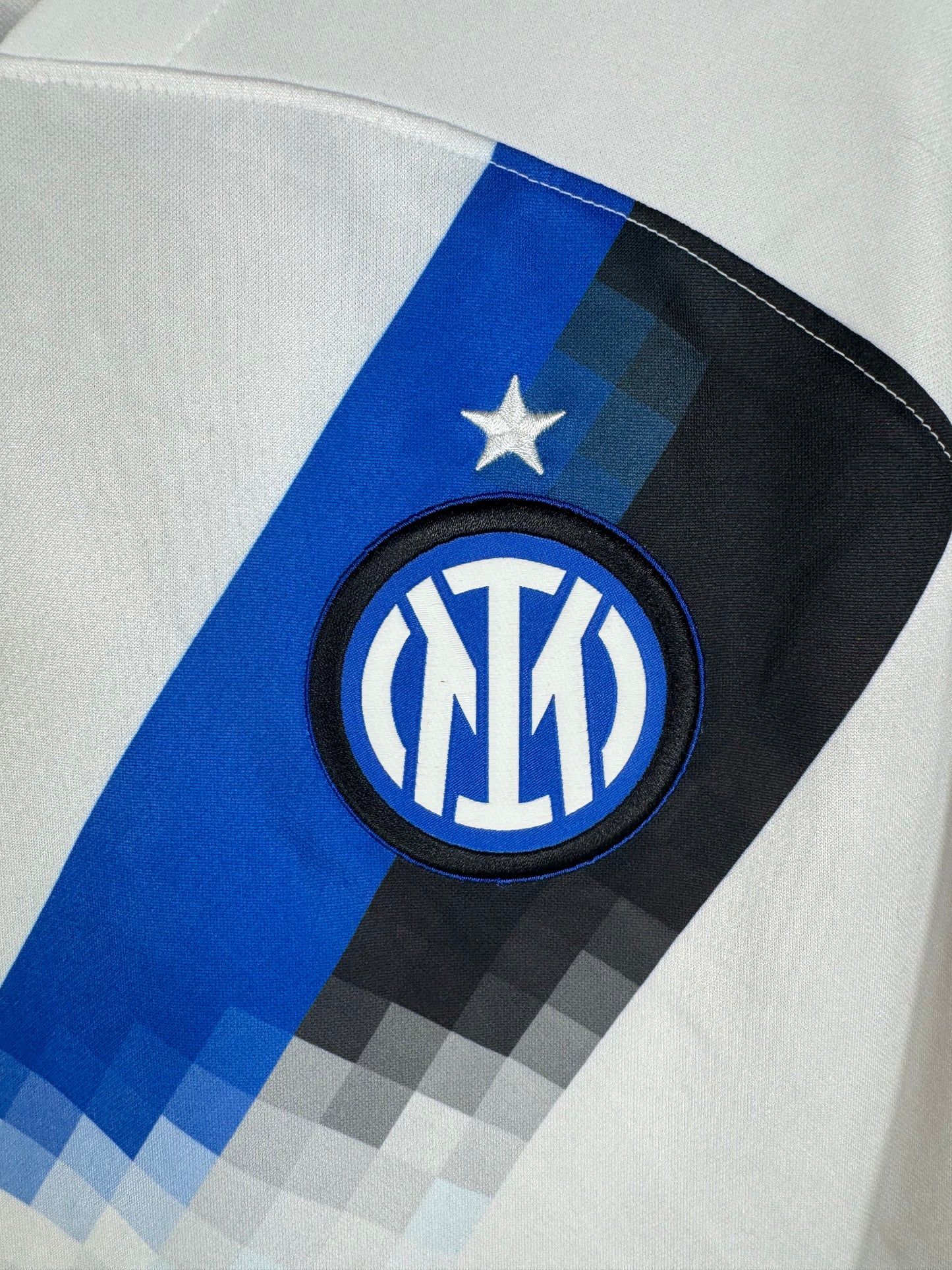 Gros plan sur l'écusson de l'Inter Milan et l'étoile placés sur la bande diagonale pixelisée.