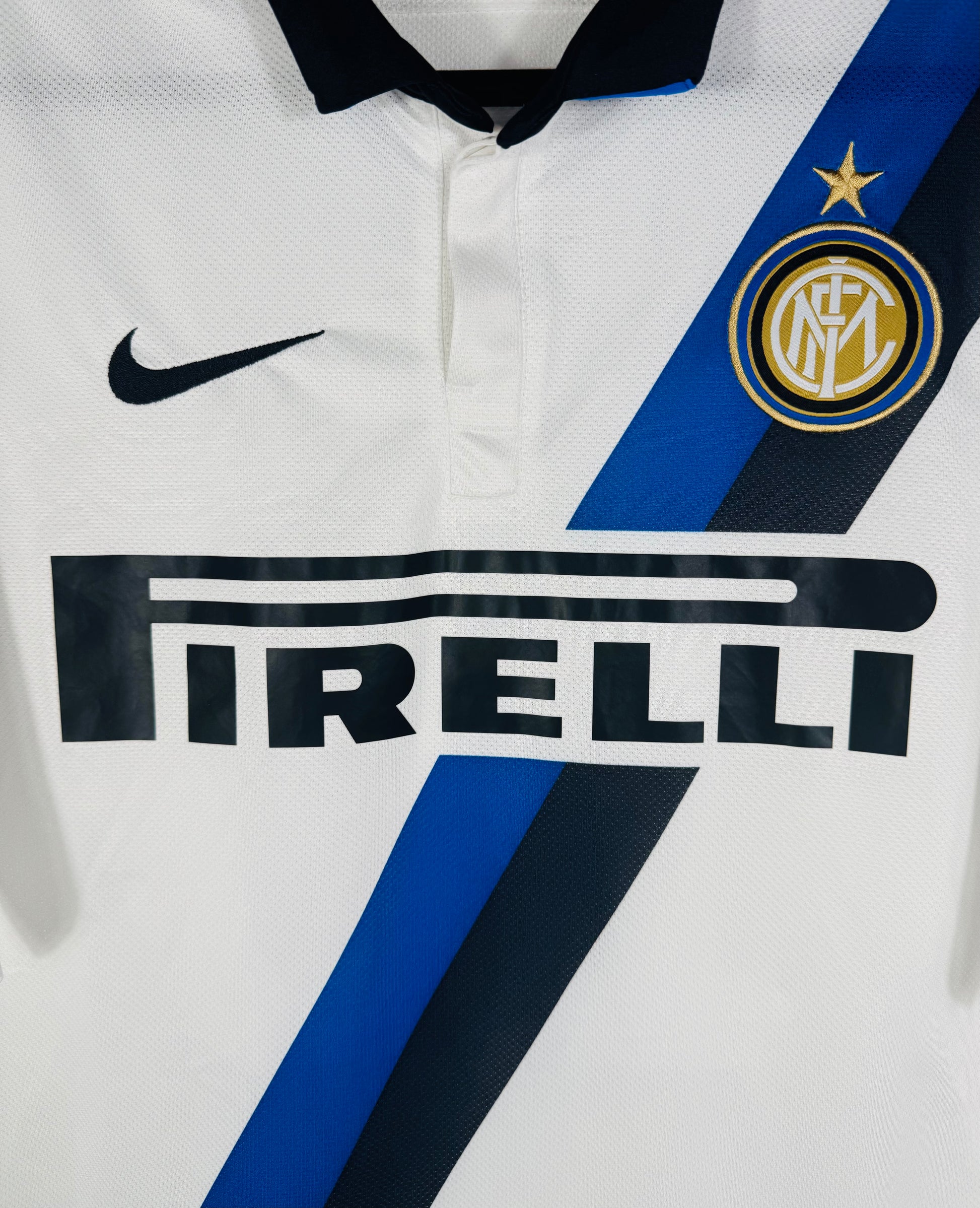 Gros plan sur le sponsor Pirelli noir, le logo Nike et l'écusson Inter sur la bande diagonale.