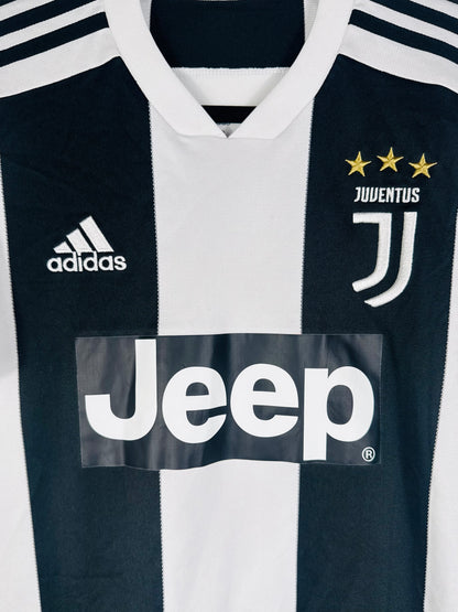 Gros plan sur le logo J de la Juventus, les 3 étoiles or et le logo Adidas.