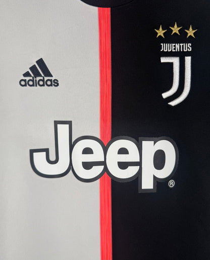 Gros plan sur le logo J de la Juventus et le sponsor Jeep sur le design bicolore.