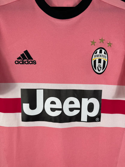 Gros plan sur l'écusson de la Juventus avec ses 3 étoiles d'or et le logo Adidas noir sur le maillot rose.