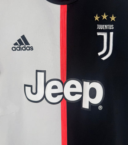 Gros plan sur le logo J de la Juventus, le logo Adidas et le sponsor Jeep sur fond bicolore.