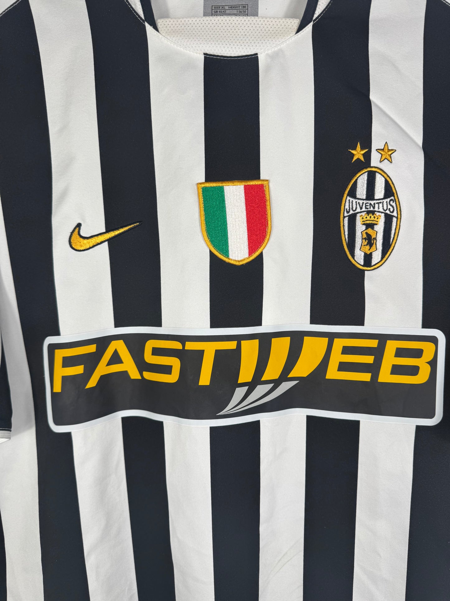 Gros plan sur l'écusson tricolore du Scudetto, le logo Juventus et le sponsor Fastweb.