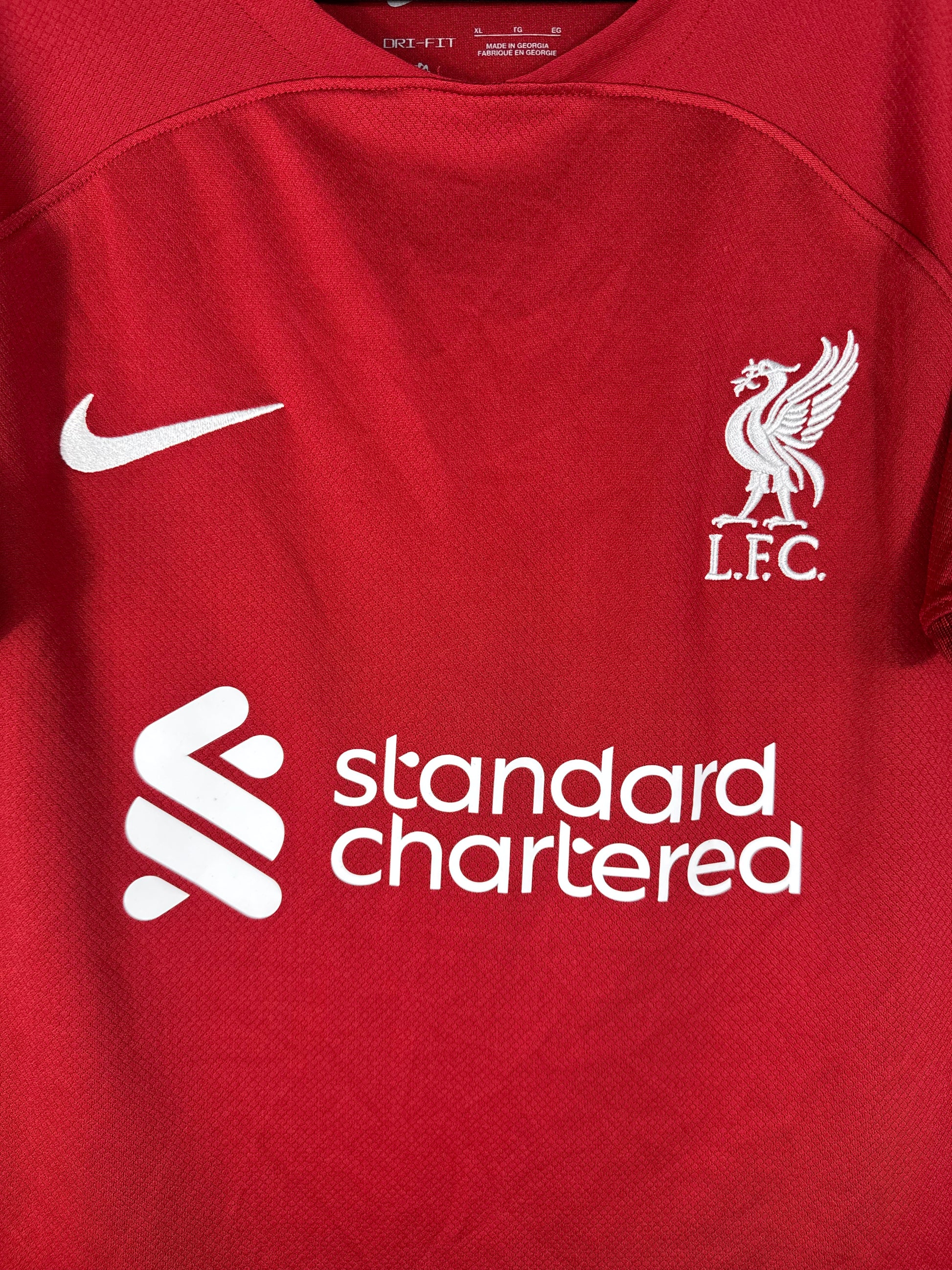 Gros plan sur l'écusson du Liverbird de Liverpool et le logo Nike blanc sur le torse.