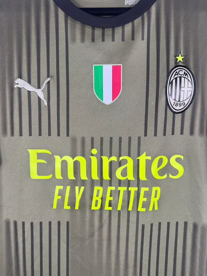 Gros plan sur le patch tricolore Scudetto, le logo Puma et l'écusson Milan monochrome.
