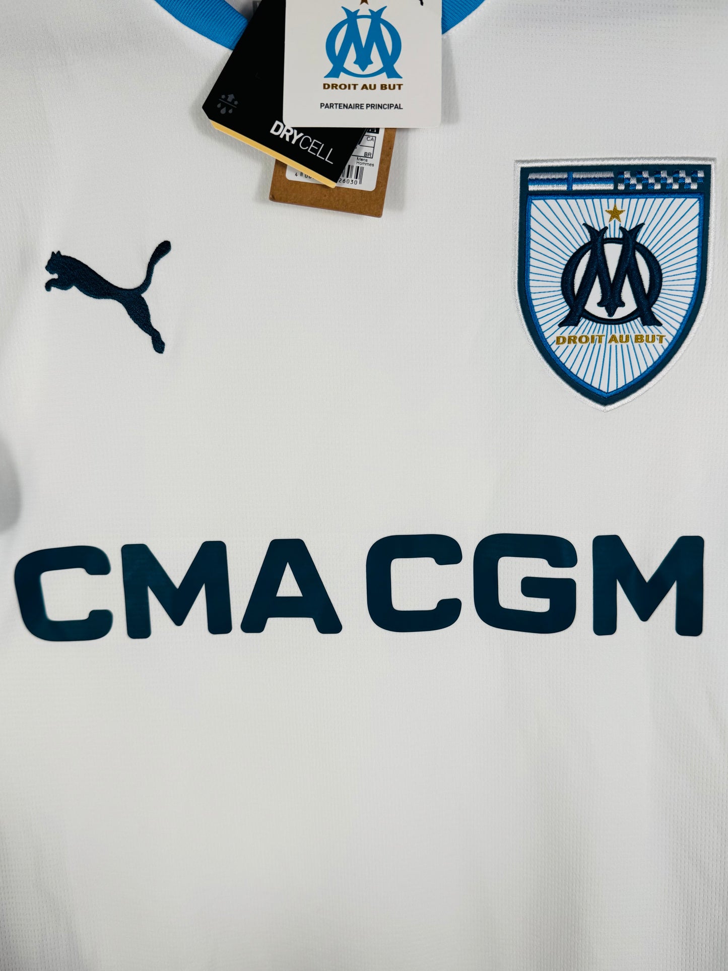 Gros plan sur l'écusson de l'OM et le logo Puma sur la poitrine.