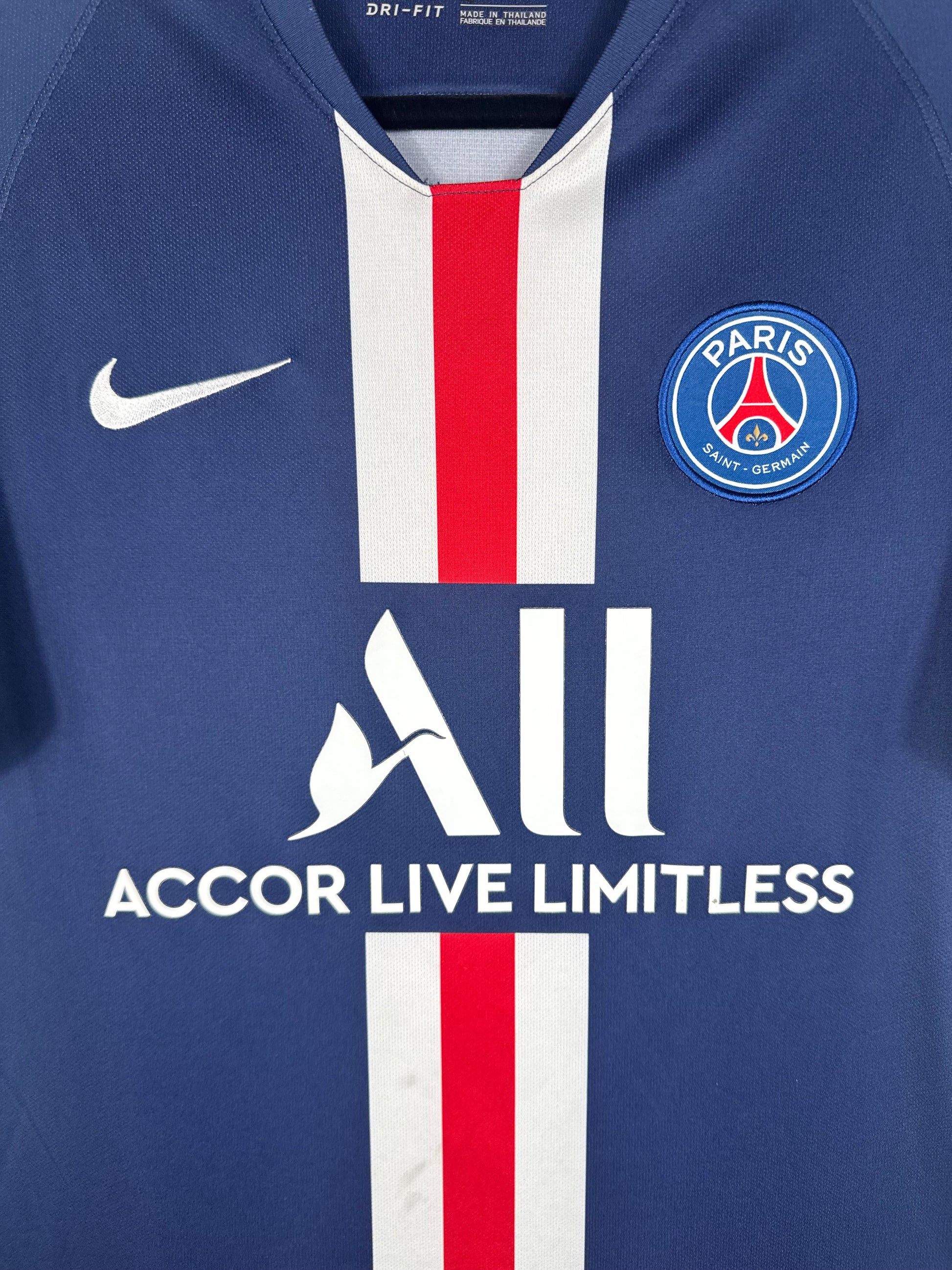 Gros plan sur l'écusson du Paris Saint-Germain et le swoosh Nike sur la bande rouge