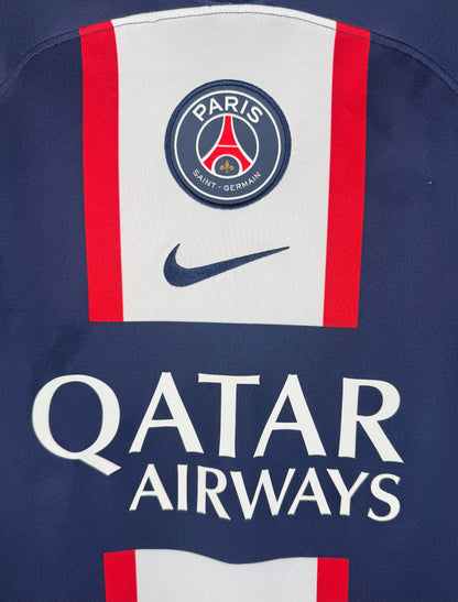 Gros plan sur l'écusson Paris Saint-Germain et le sponsor Qatar Airways sur la bande centrale.