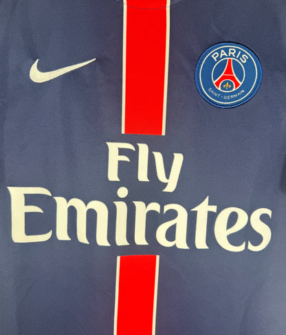 Gros plan sur l'écusson Paris Saint-Germain et le logo Nike sur la bande rouge.