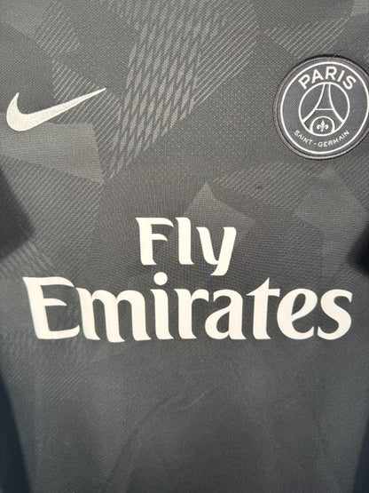 Gros plan sur l'écusson du PSG et le logo Nike argentés sur le tissu technique camouflage.