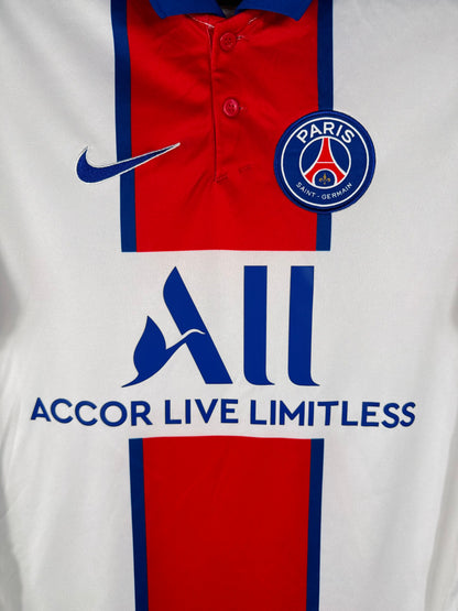 Gros plan sur l'écusson du Paris Saint-Germain et le logo Nike bleu sur le maillot blanc.