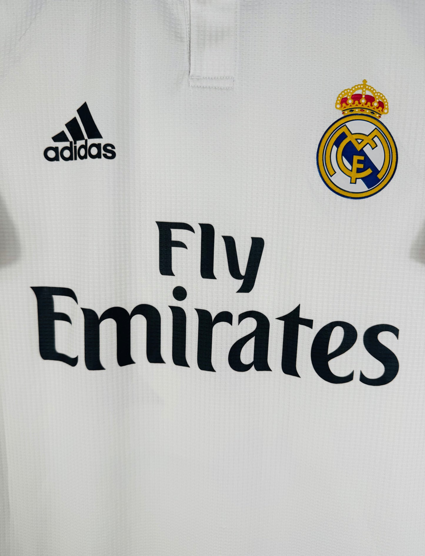 Gros plan sur le sponsor Fly Emirates et l'écusson thermocollé (version pro) du Real Madrid.