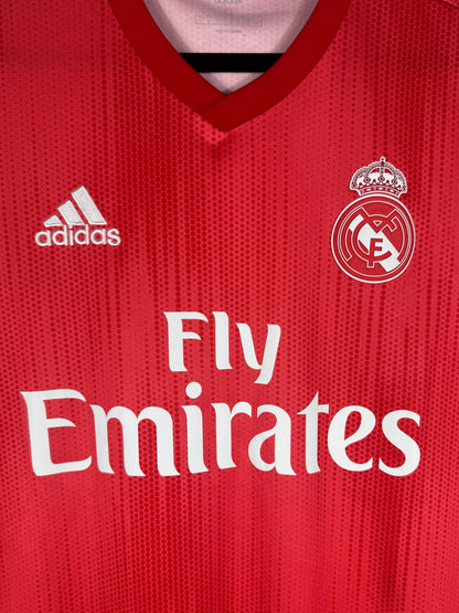 Gros plan sur l'écusson Real Madrid blanc et le sponsor Fly Emirates sur le tissu Parley.