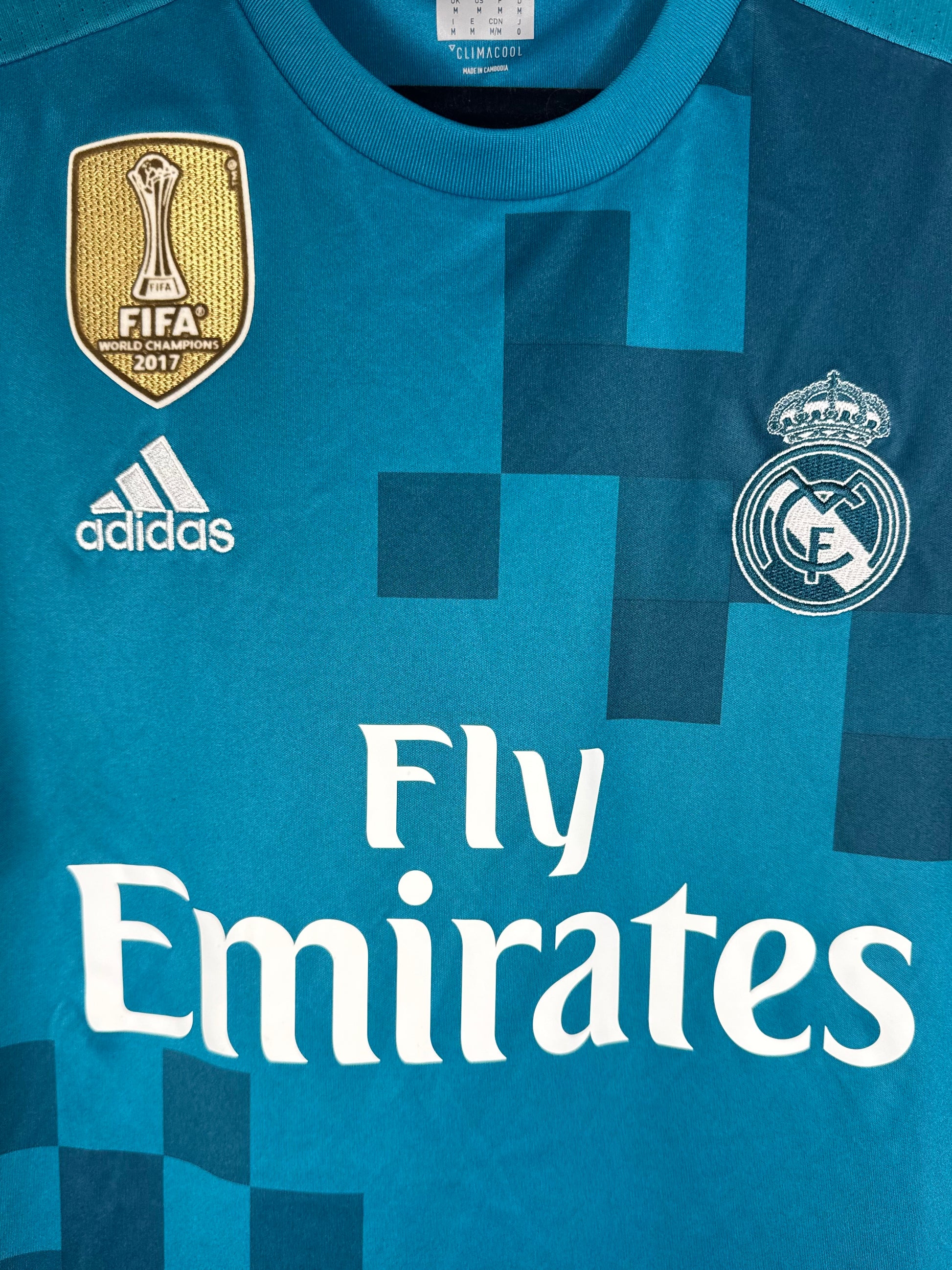 Gros plan sur le badge doré FIFA World Champions 2016 et l'écusson du Real.