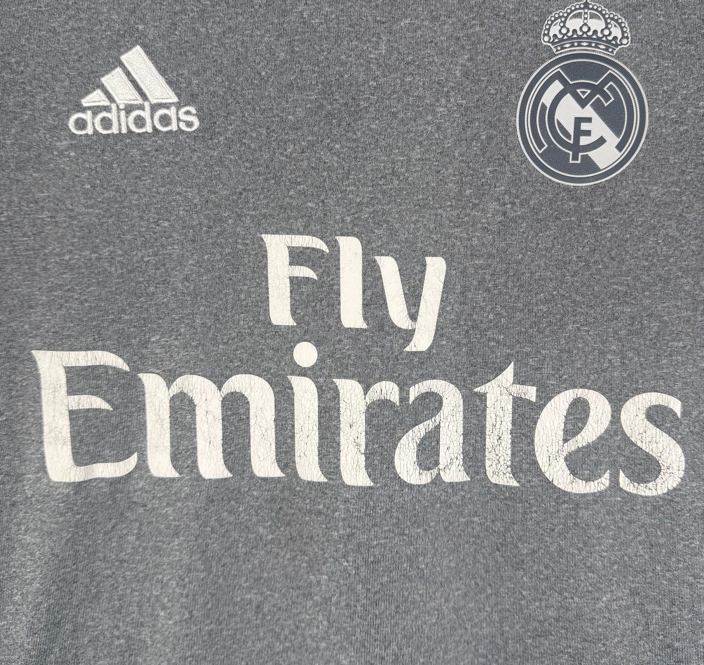 Gros plan sur l'écusson Real Madrid monochrome et la texture effet coton du tissu.