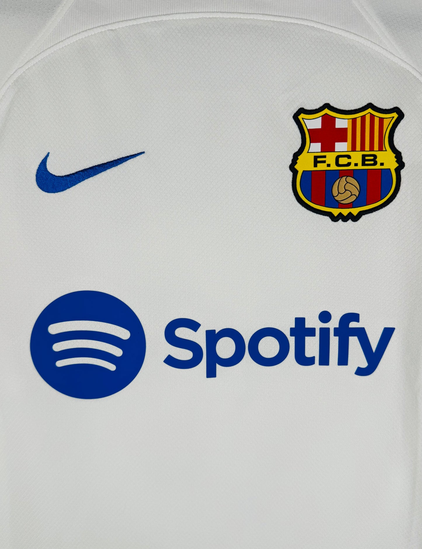 Gros plan sur l'écusson FC Barcelone style 1978 et le sponsor Spotify bleu roi.