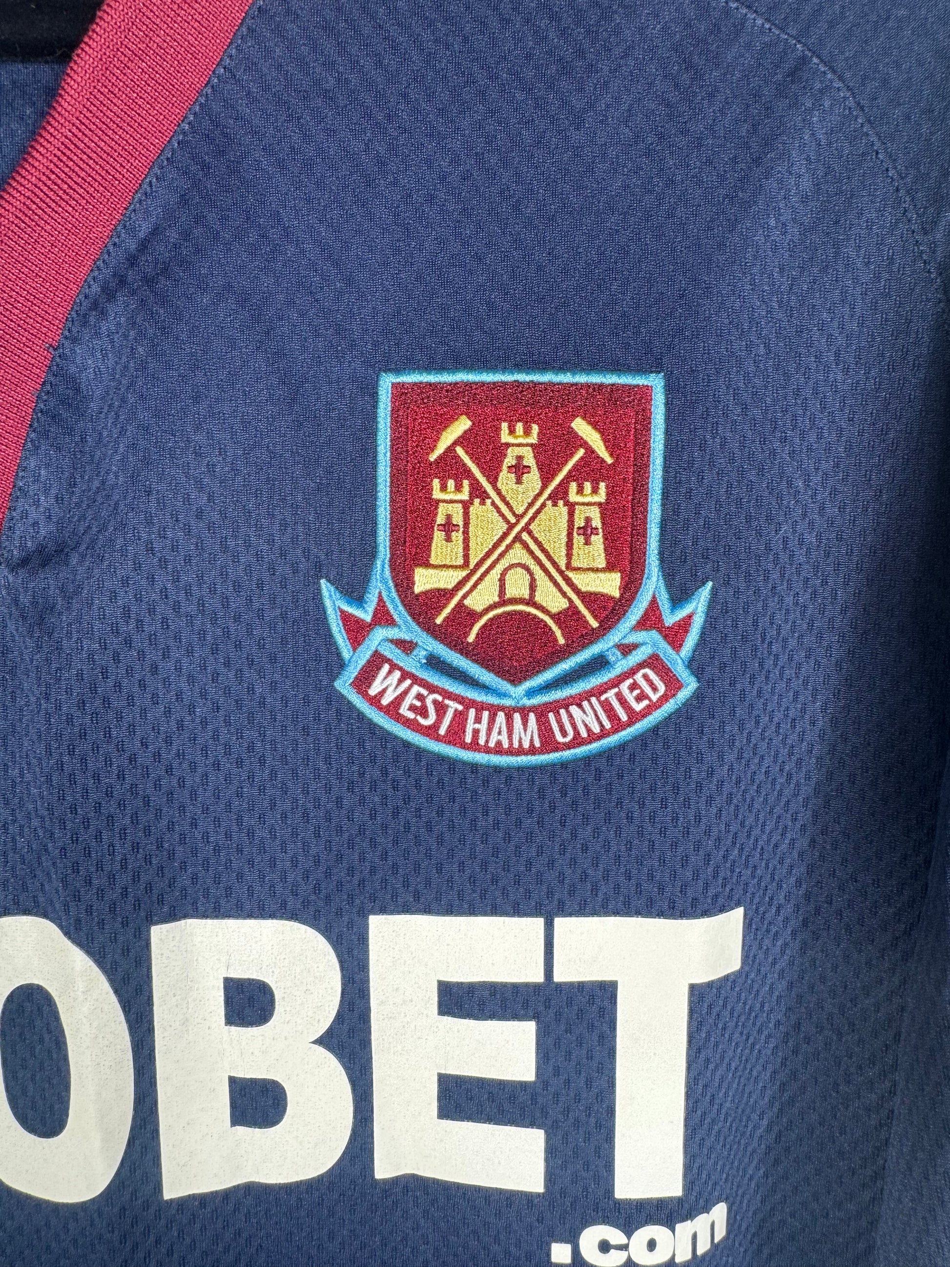 Gros plan sur l'écusson des Hammers "Castle" et le sponsor SBOBET.