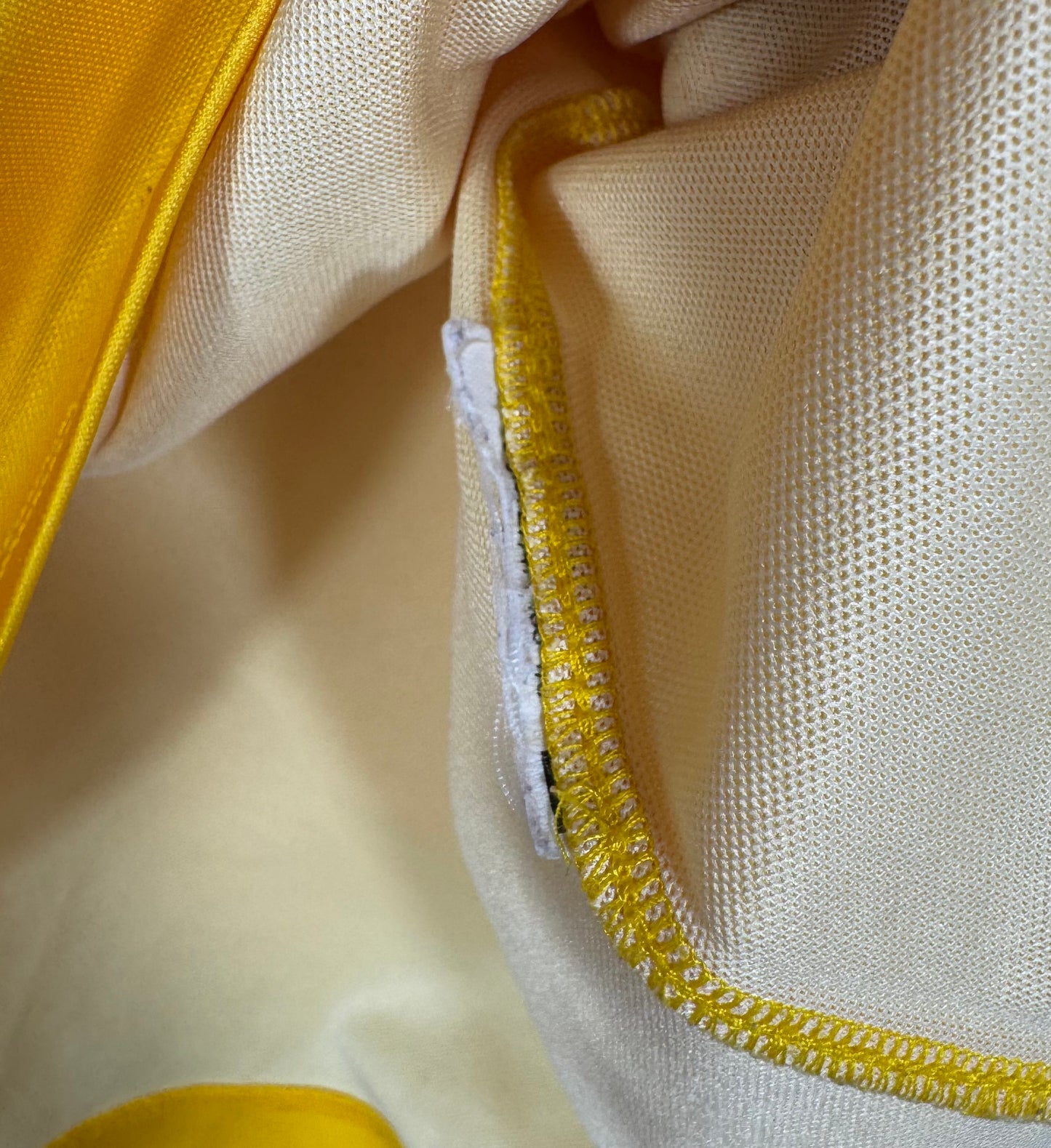 Photo de détail montrant l'étiquette de lavage coupée à l'intérieur du maillot.