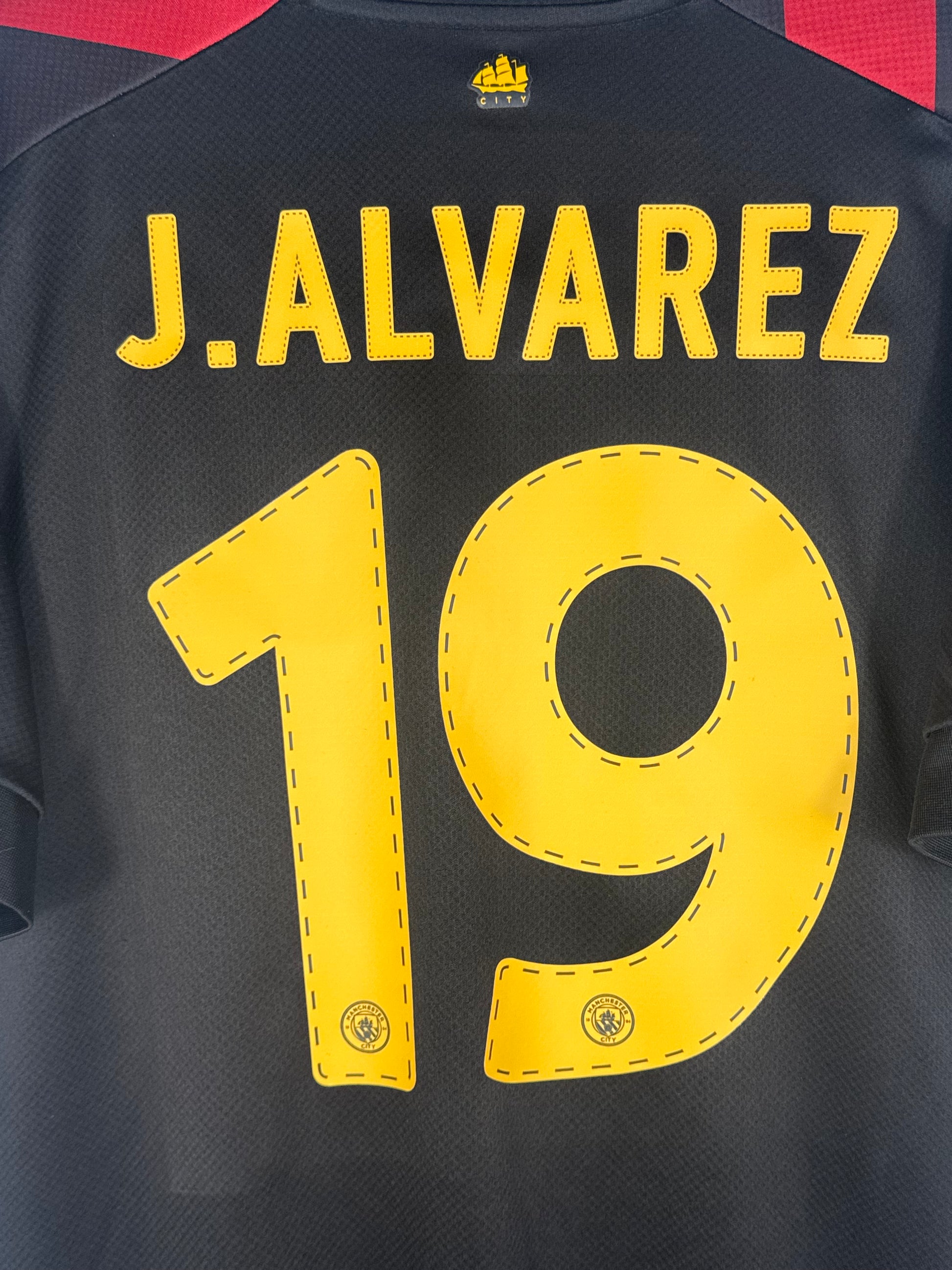 Zoom sur le nom J.ALVAREZ et le numéro 19 jaune police officielle de coupe.