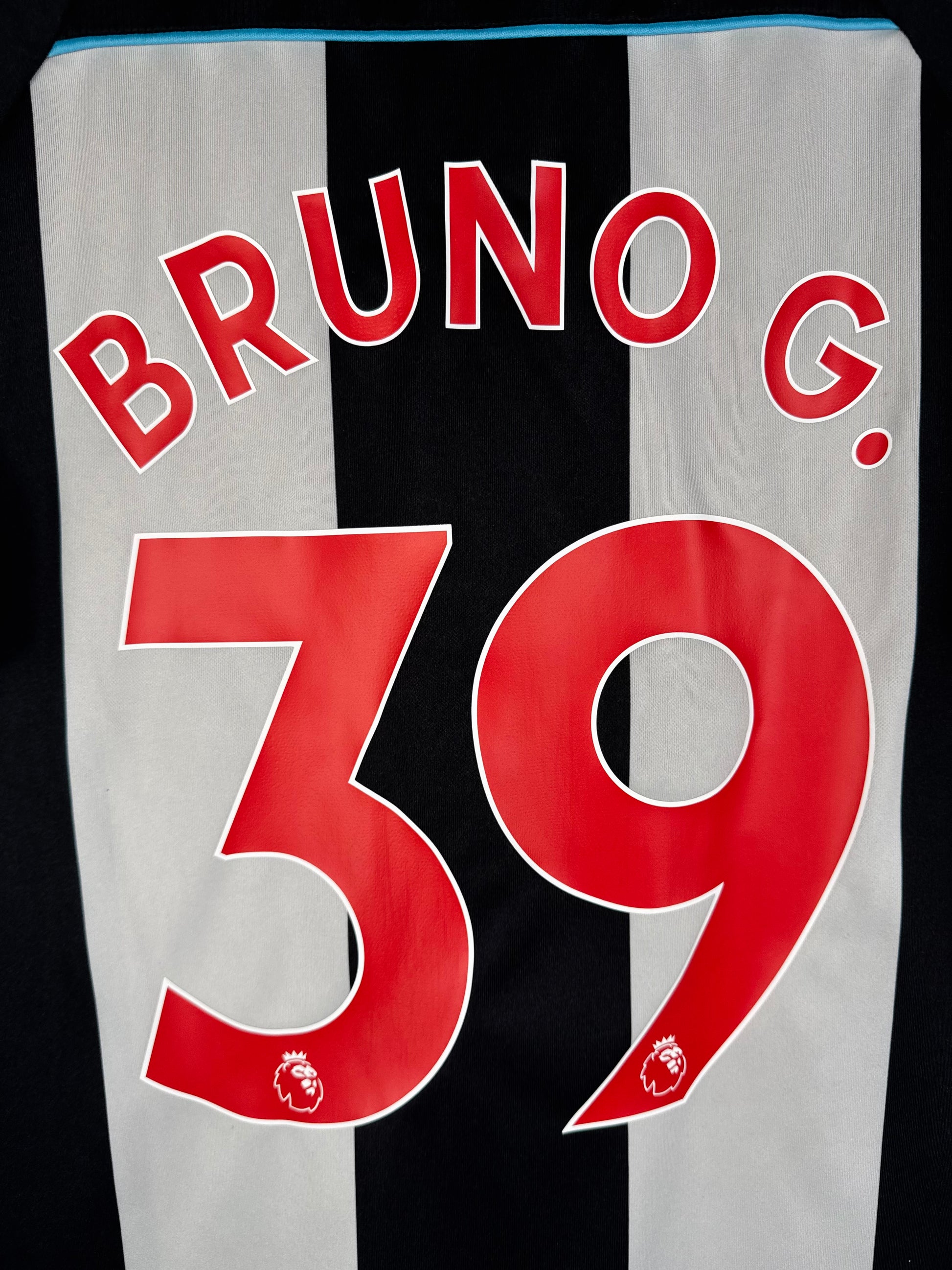 Zoom sur le nom BRUNO G. et le numéro 39 blanc, police officielle Premier League avec le lion au bas du chiffre.