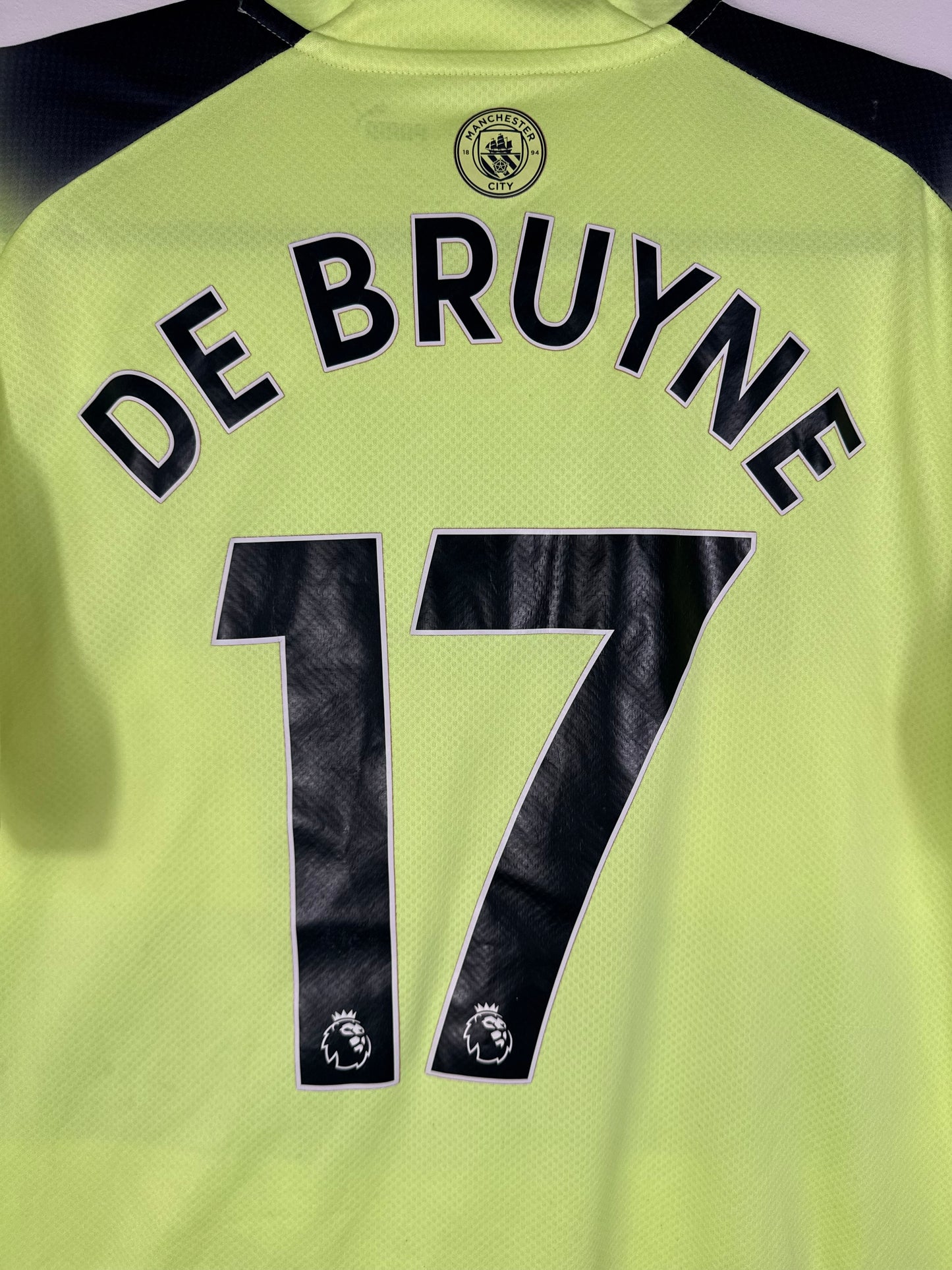 Zoom sur le nom DE BRUYNE et le numéro 17 noir, police officielle Premier League 2023.