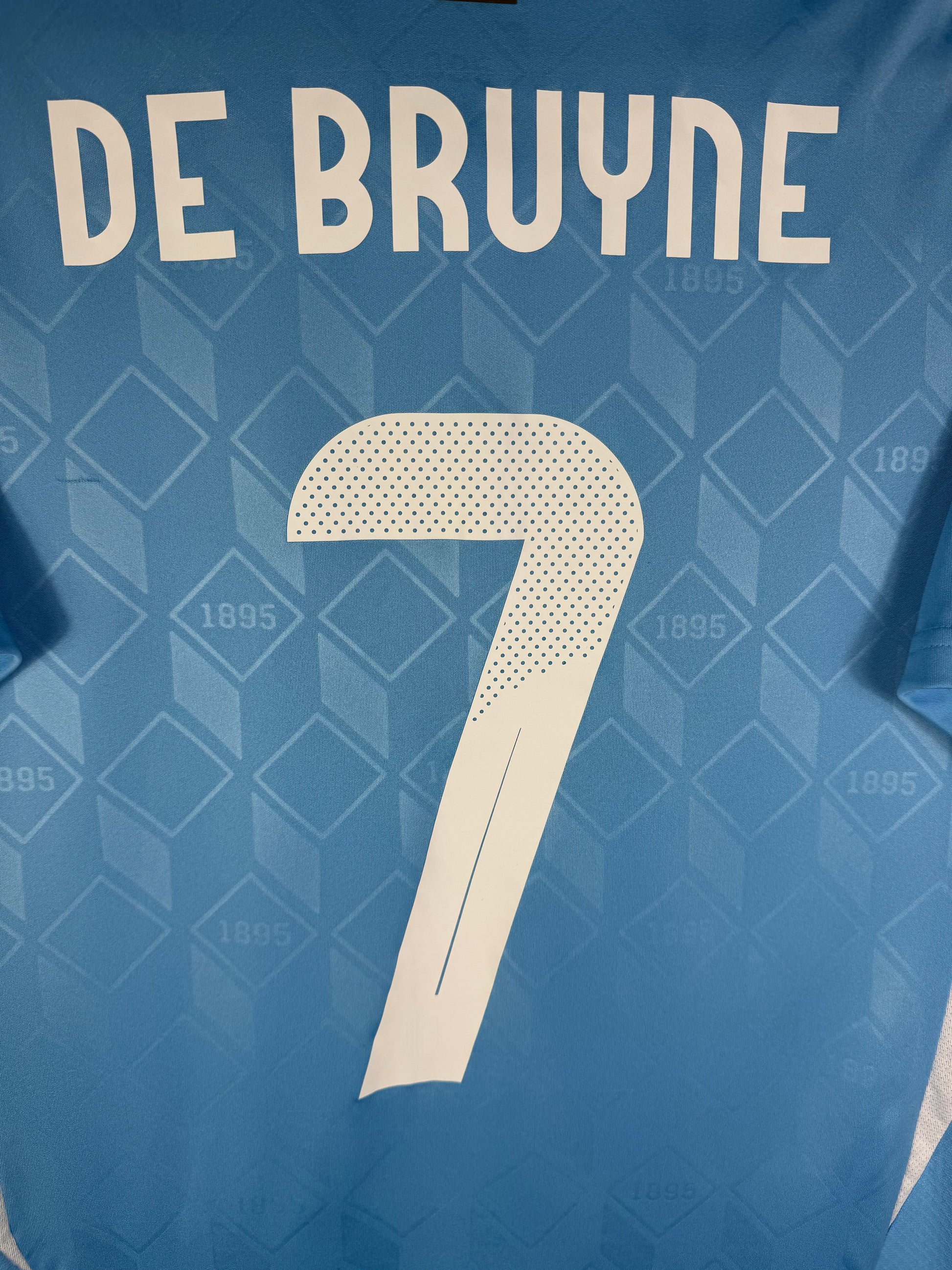 Zoom sur le nom DE BRUYNE et le numéro 7 blanc avec motif 3D intégré, police officielle Belgique Euro 2024.