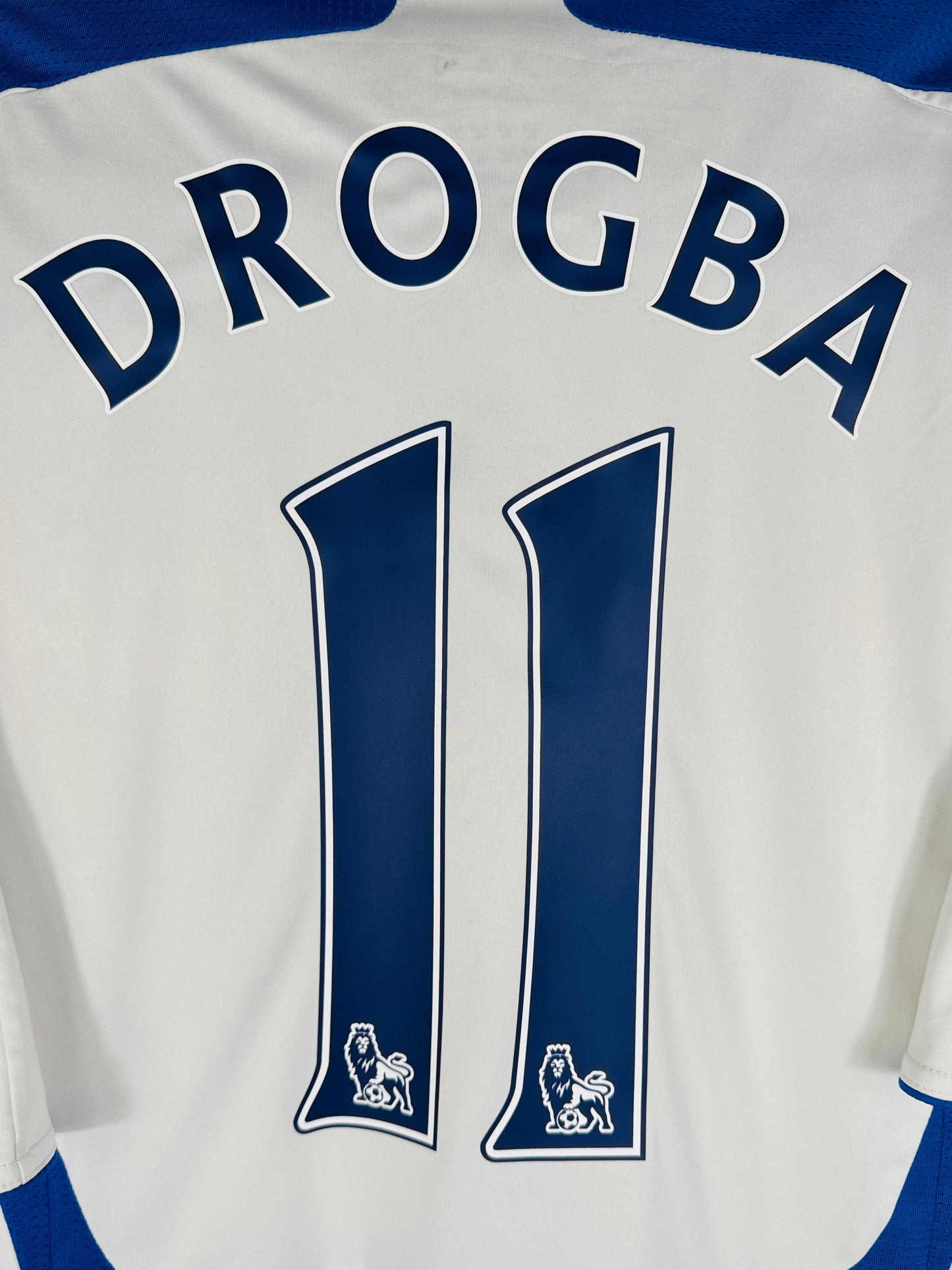Zoom sur le nom DROGBA et le numéro 11 en typographie officielle Premier League.