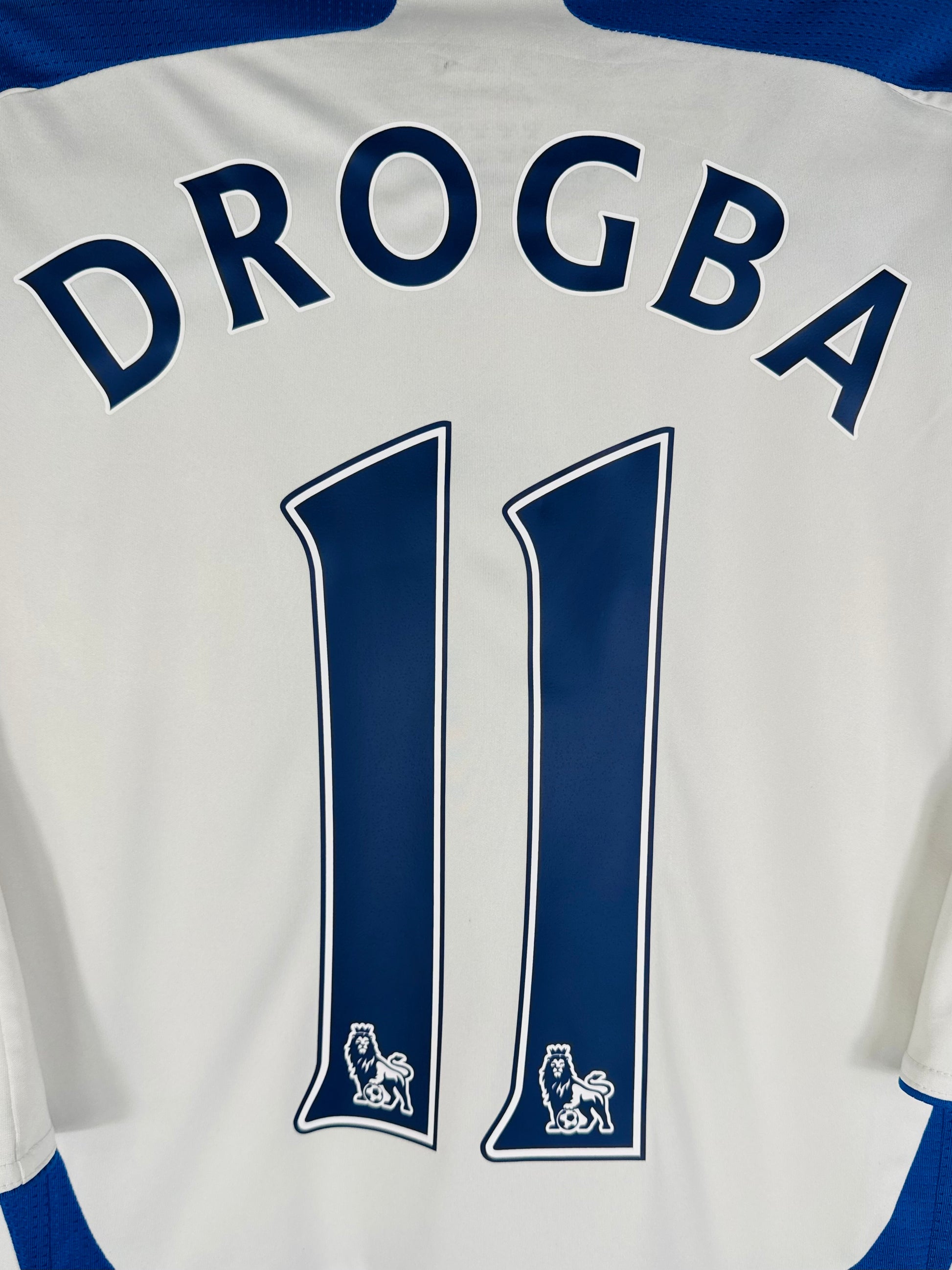 Zoom sur le nom DROGBA et le numéro 11 en typographie officielle Premier League.
