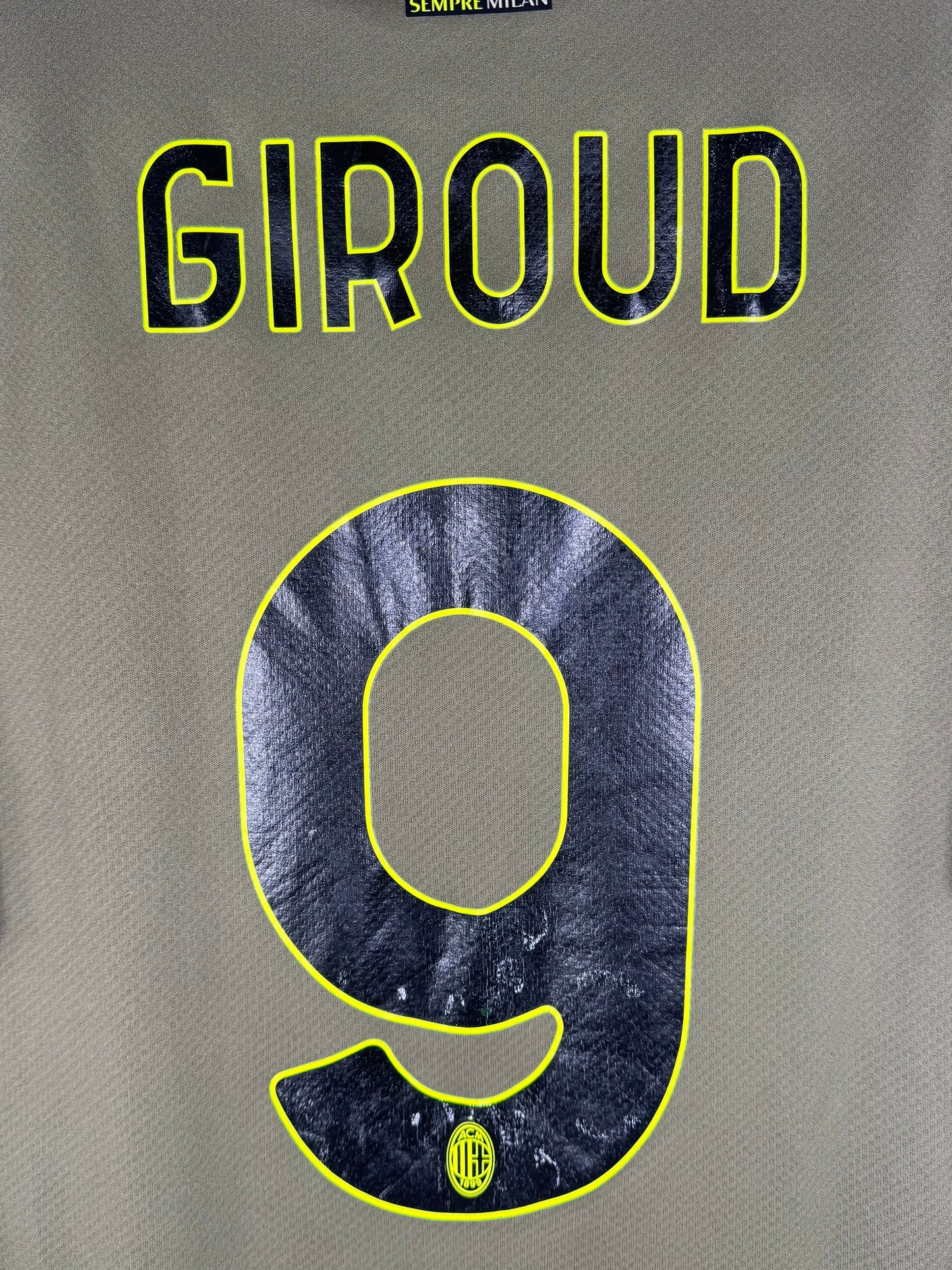 Zoom sur le nom GIROUD et le numéro 9 jaune fluo avec contour noir.