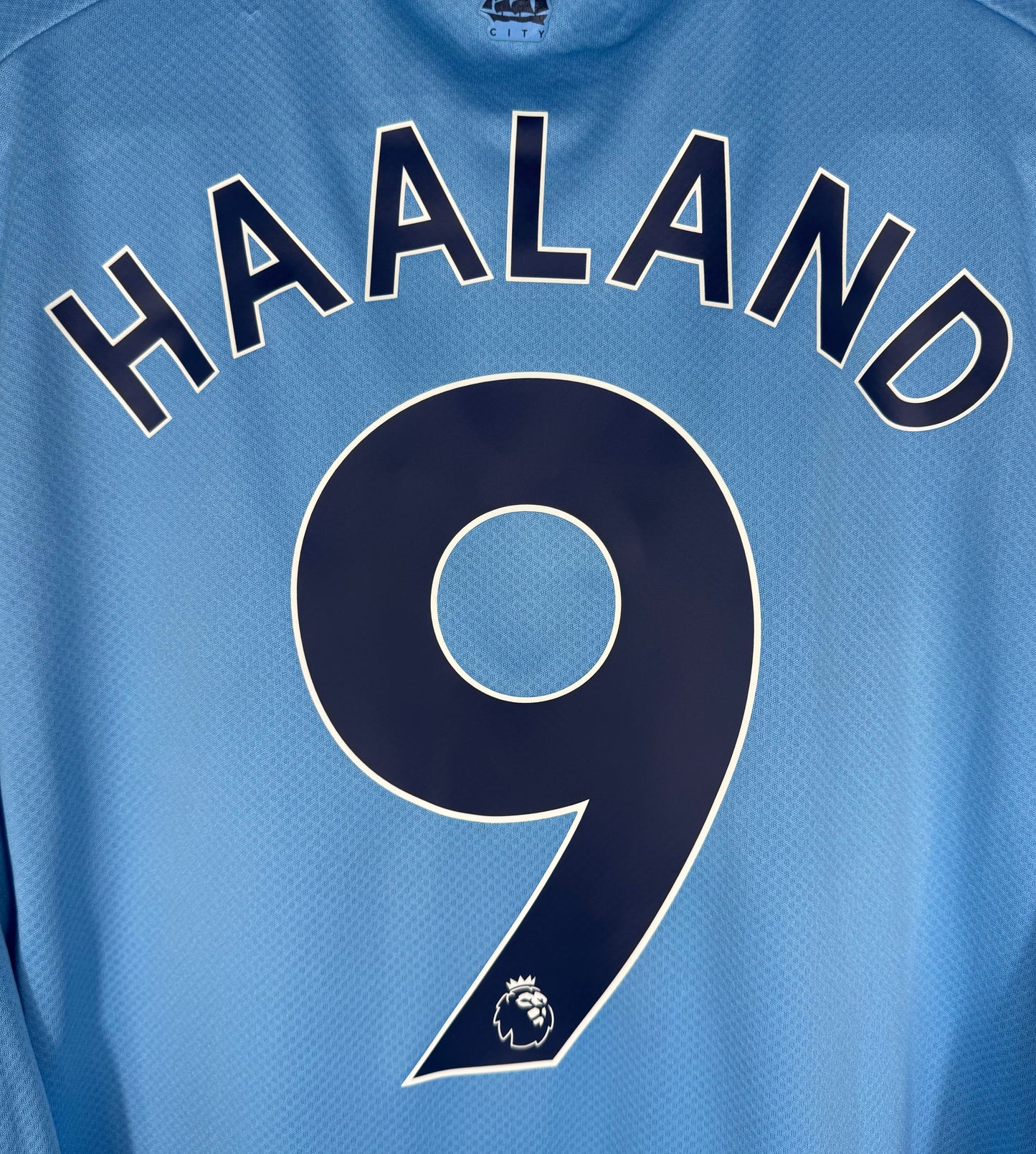 Zoom sur le nom HAALAND et le numéro 9 avec la typographie officielle de la saison du triplé.