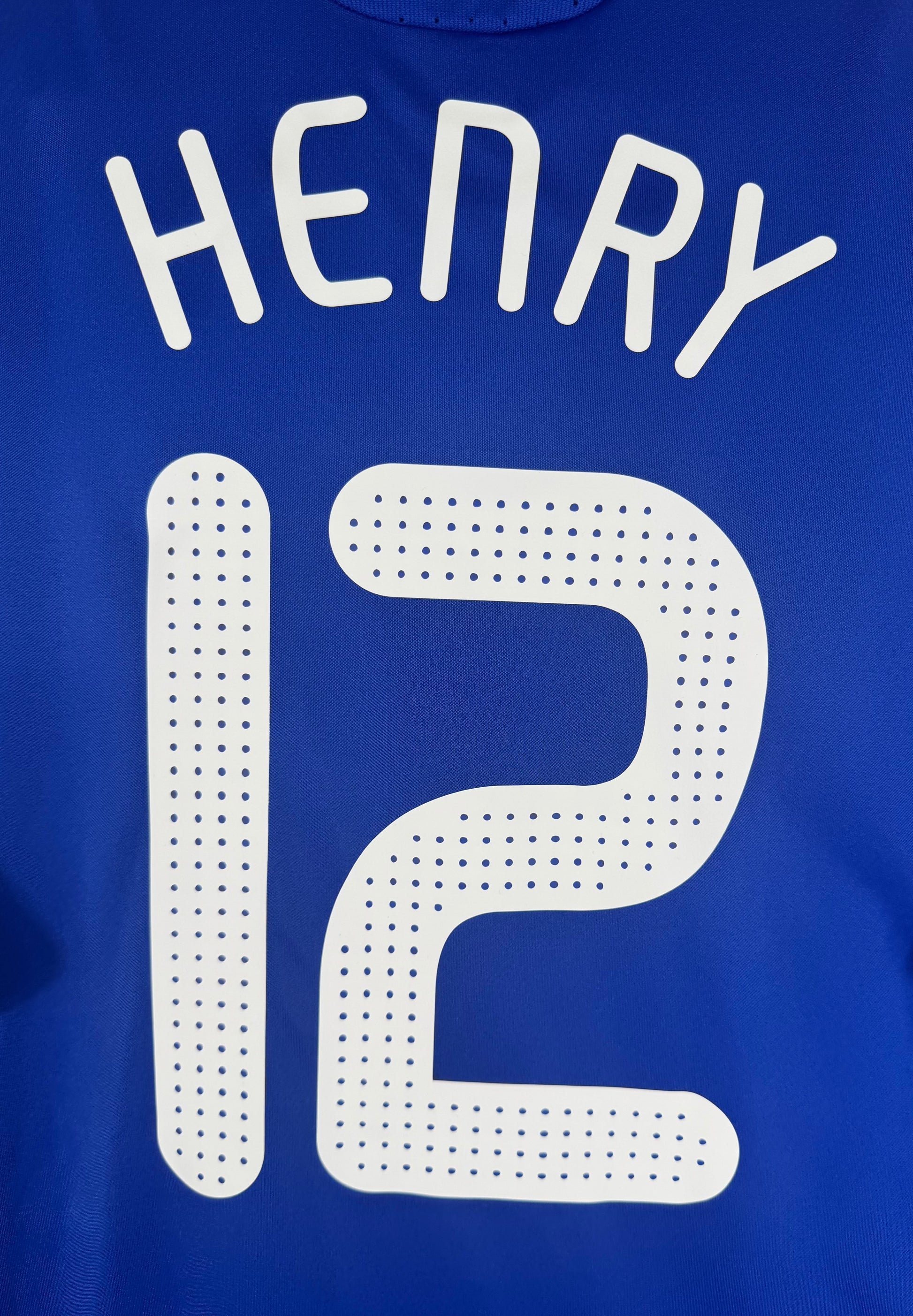 Zoom sur la typographie pointillée officielle du nom HENRY et numéro 12.