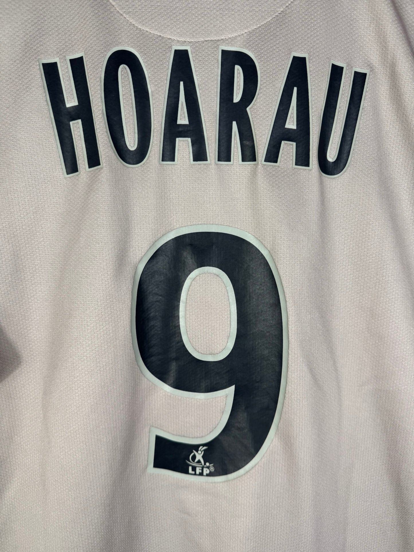 Zoom sur le nom HOARAU et le numéro 9 bleu marine avec le logo du PSG intégré dans le chiffre.