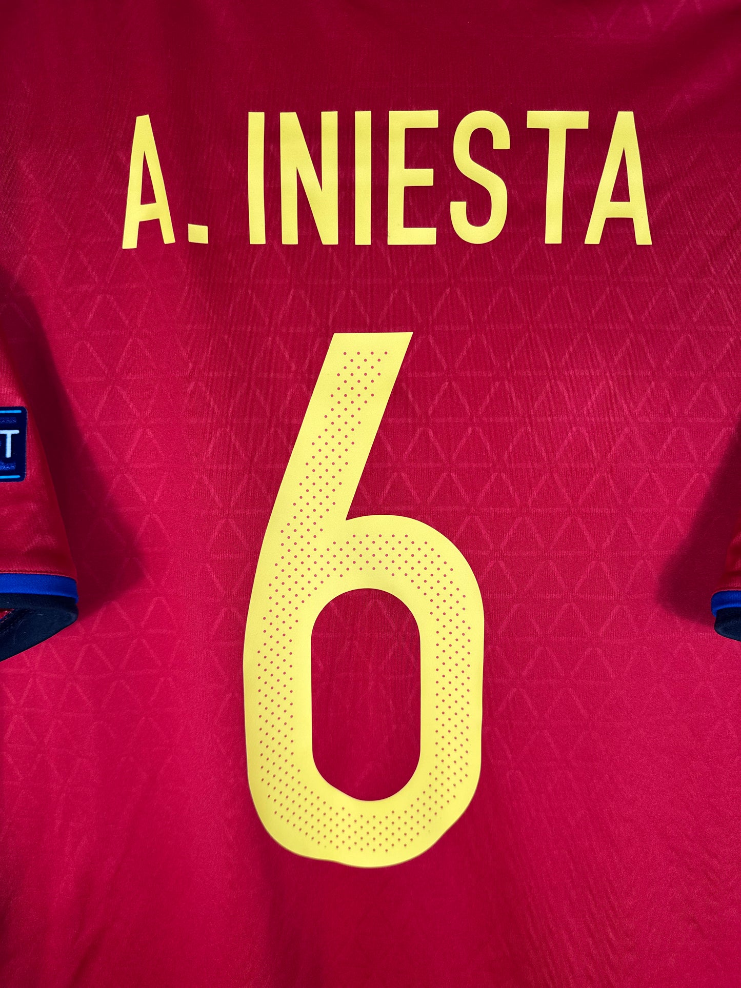 Zoom sur le nom INIESTA et le numéro 6 jaune, police officielle Adidas pour l'Euro 2016.