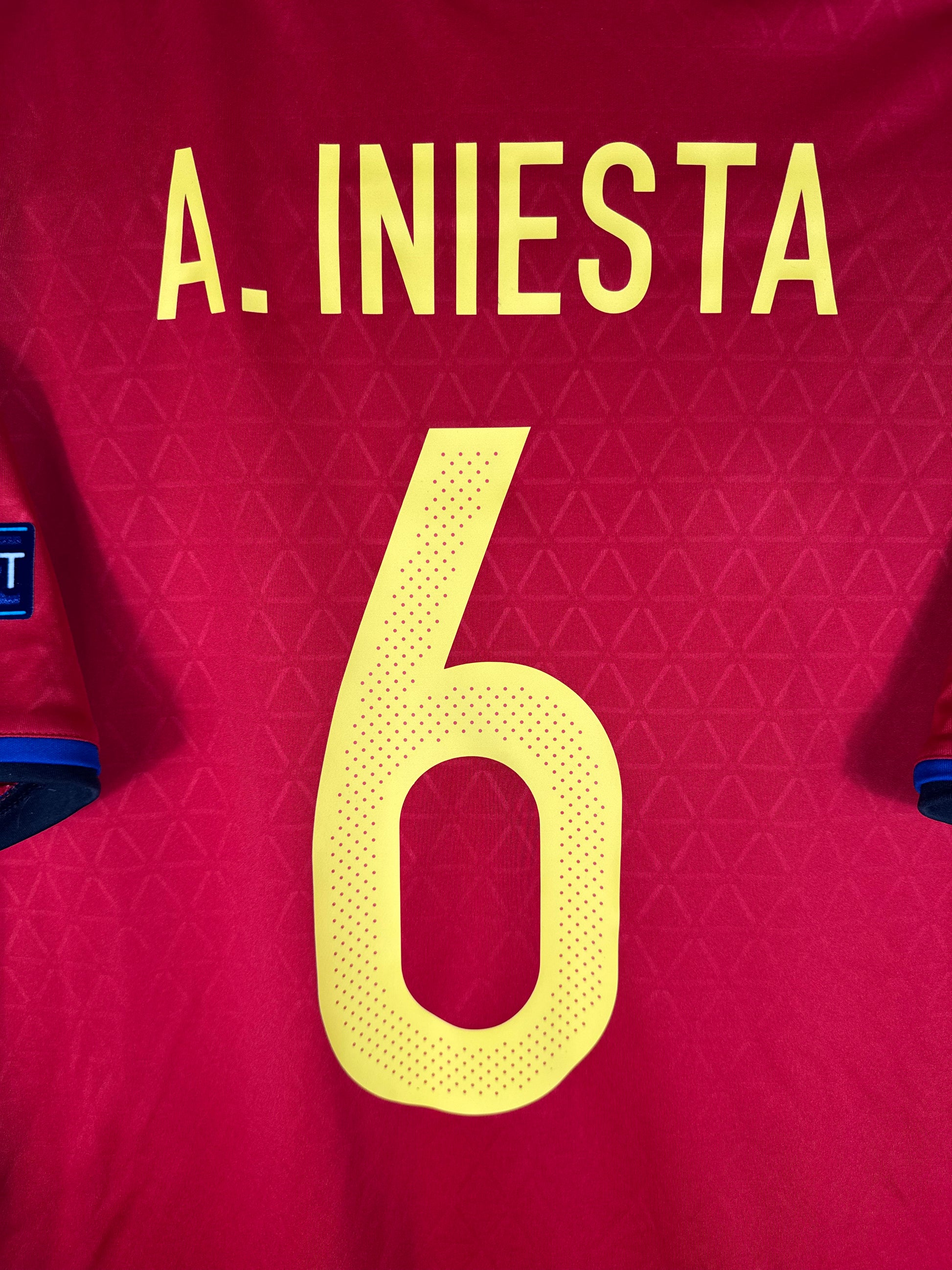 Zoom sur le nom INIESTA et le numéro 6 jaune, police officielle Adidas pour l'Euro 2016.