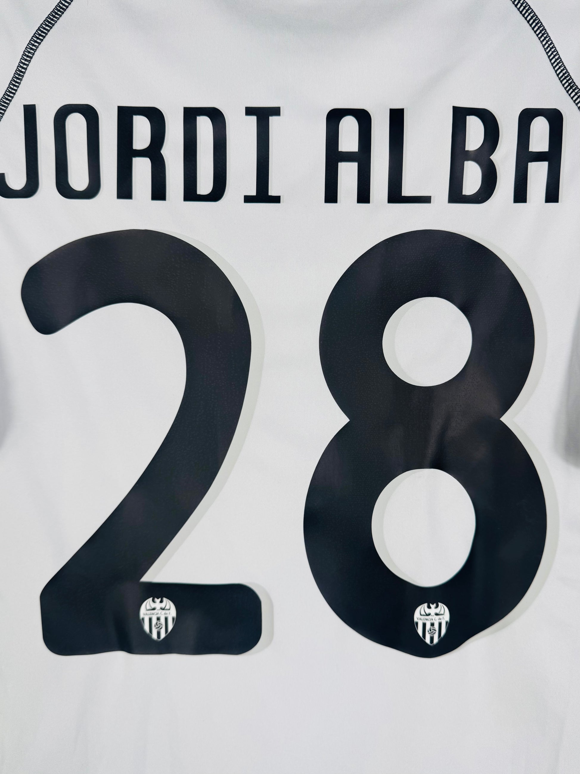 Zoom sur le nom JORDI ALBA et le numéro 28 noir (numéro de jeune joueur).