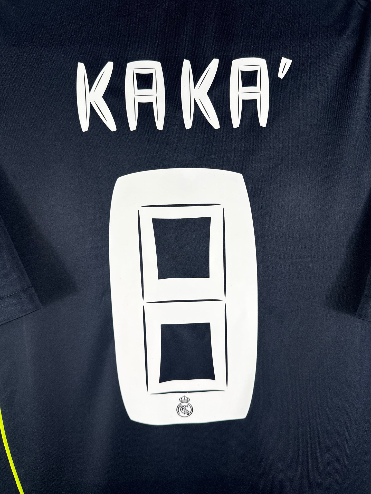 Zoom sur le nom KAKA' et le numéro 8 blanc, typographie officielle du Real Madrid 2010-2011.