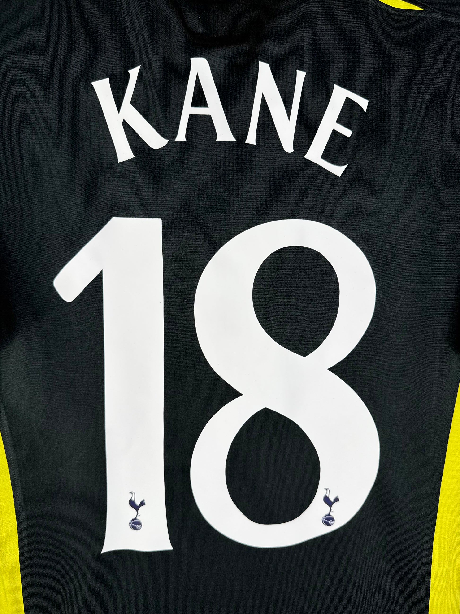 Zoom sur le nom KANE et le numéro 18 blanc avec le logo du club dans le chiffre.