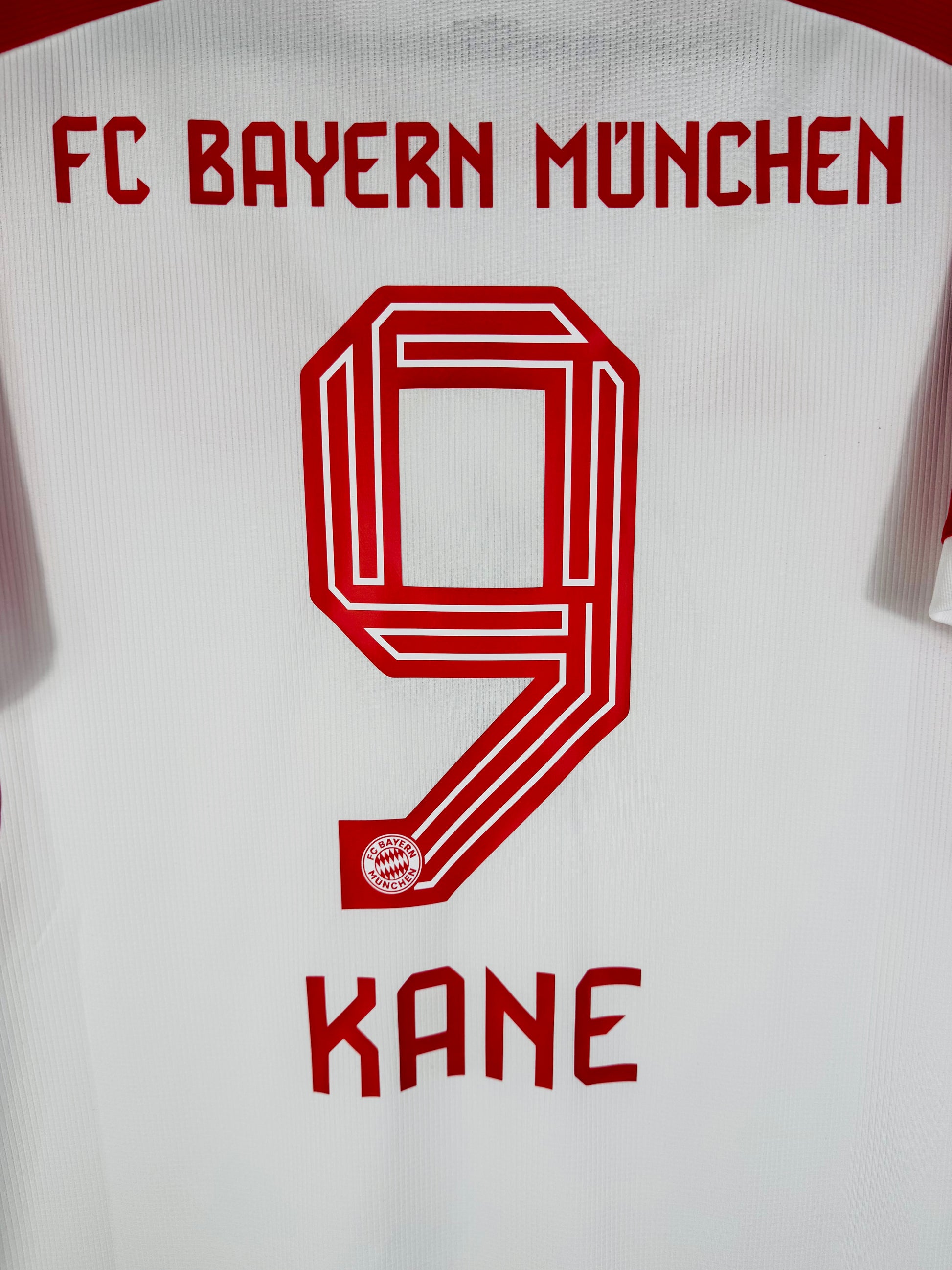 Zoom sur le nom KANE et le numéro 9 rouge, police officielle utilisée par le Bayern en Ligue des Champions.