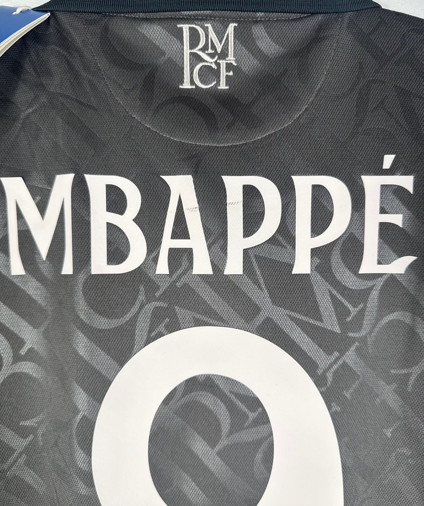 Zoom sur le nom MBAPPÉ et le numéro 9 blanc style rétro sur le maillot Third.