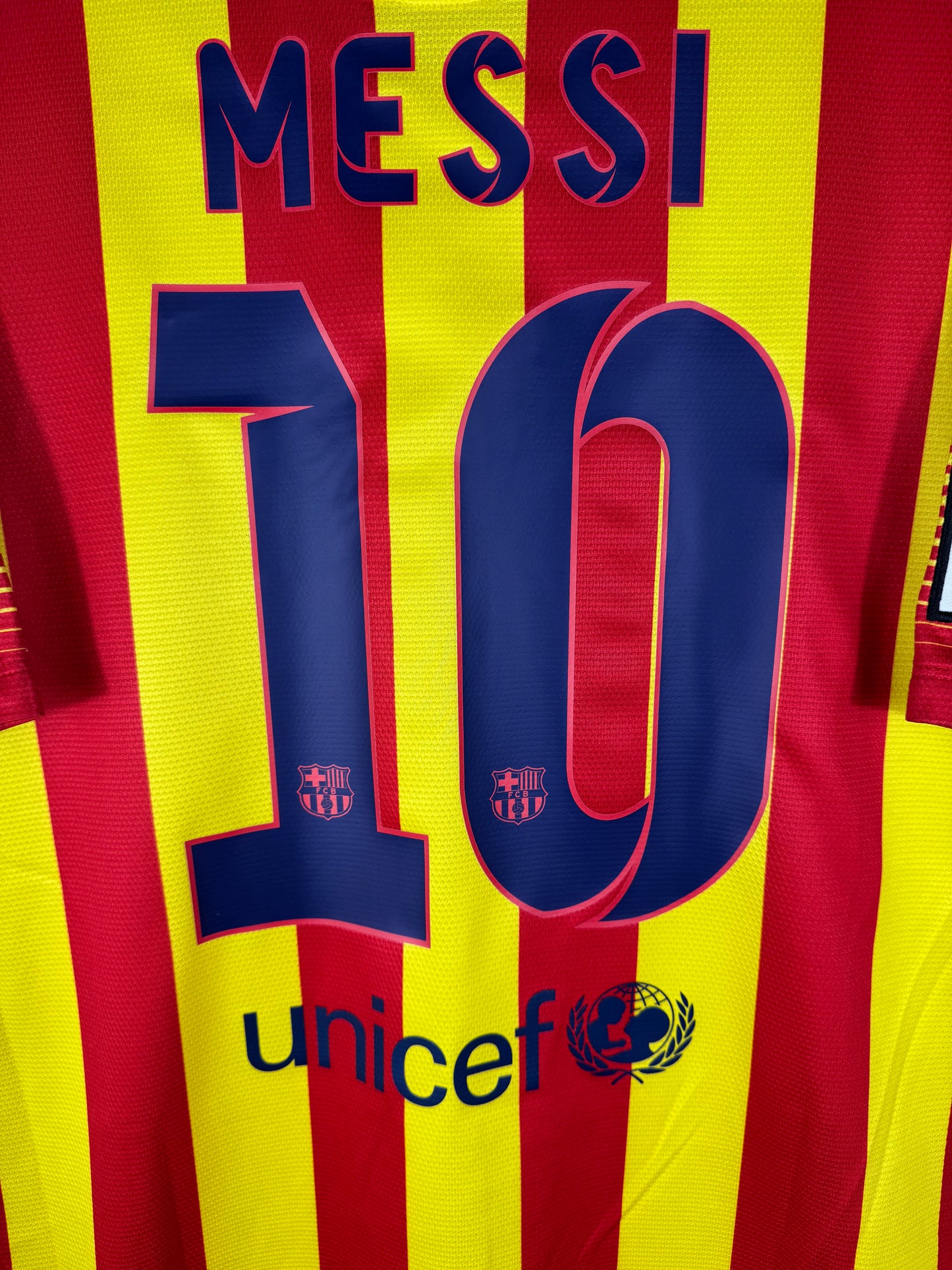 Zoom sur le nom MESSI et le numéro 10 bleu marine avec typographie officielle du FC Barcelone 2013-2014.