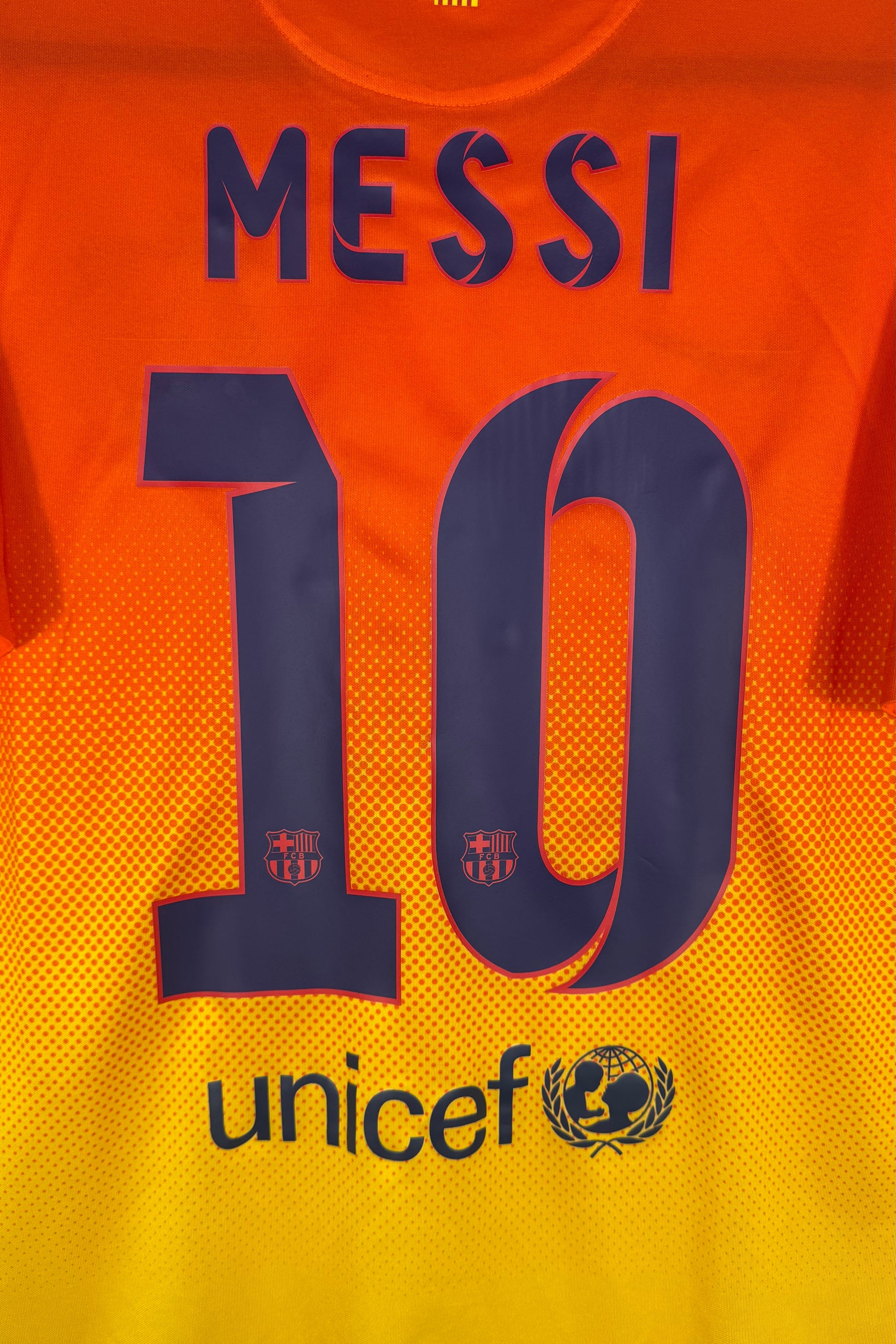 Zoom sur le nom MESSI et le numéro 10 bleu marine avec logo Unicef.