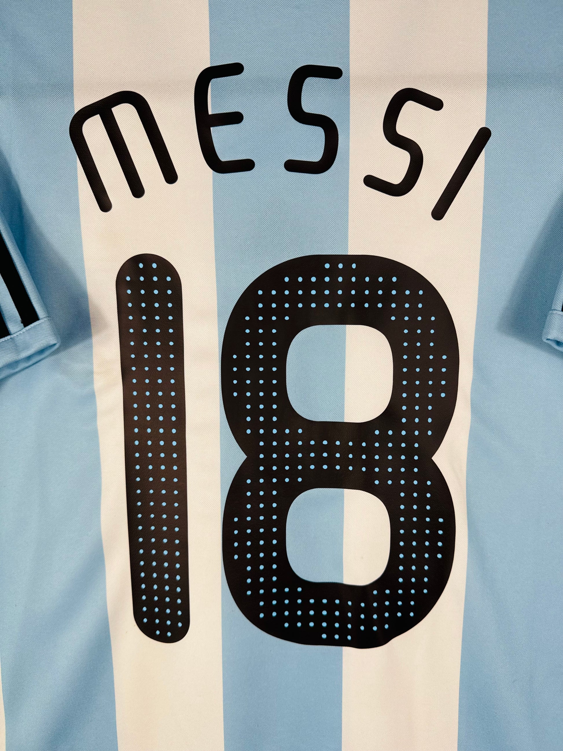 Zoom sur le nom MESSI en lettres noires, typographie officielle de l'époque.