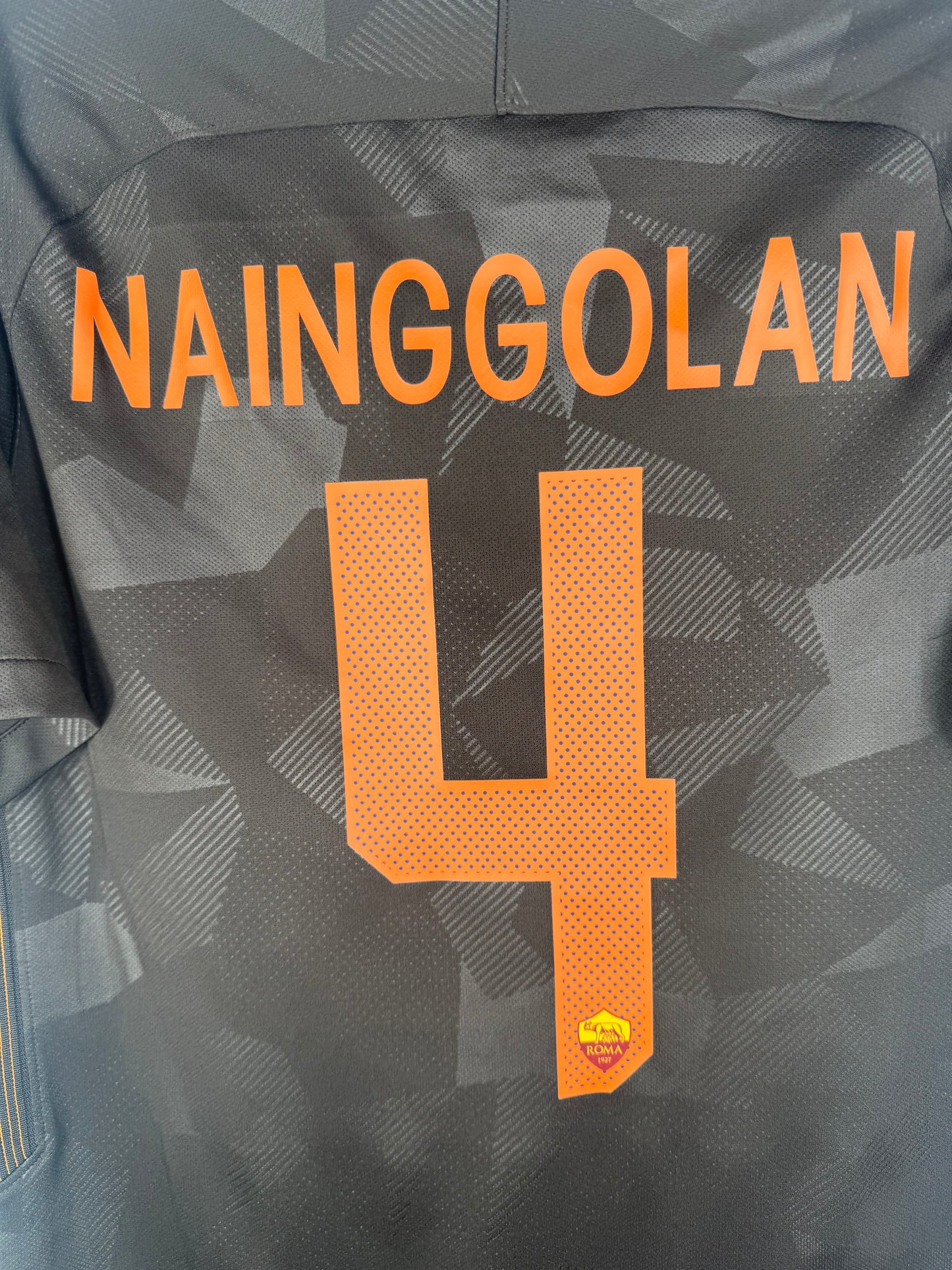 Zoom sur le nom NAINGGOLAN et le numéro 4 orange vif.