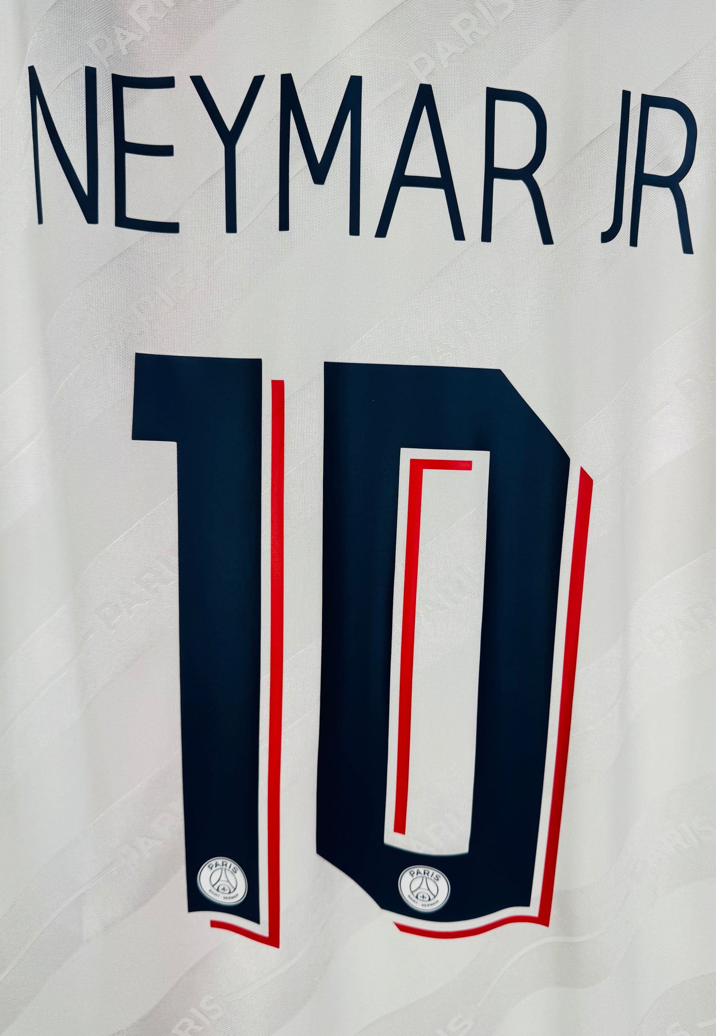 Zoom sur le nom NEYMAR JR et le numéro 10 aux couleurs rétro bleu et rouge.