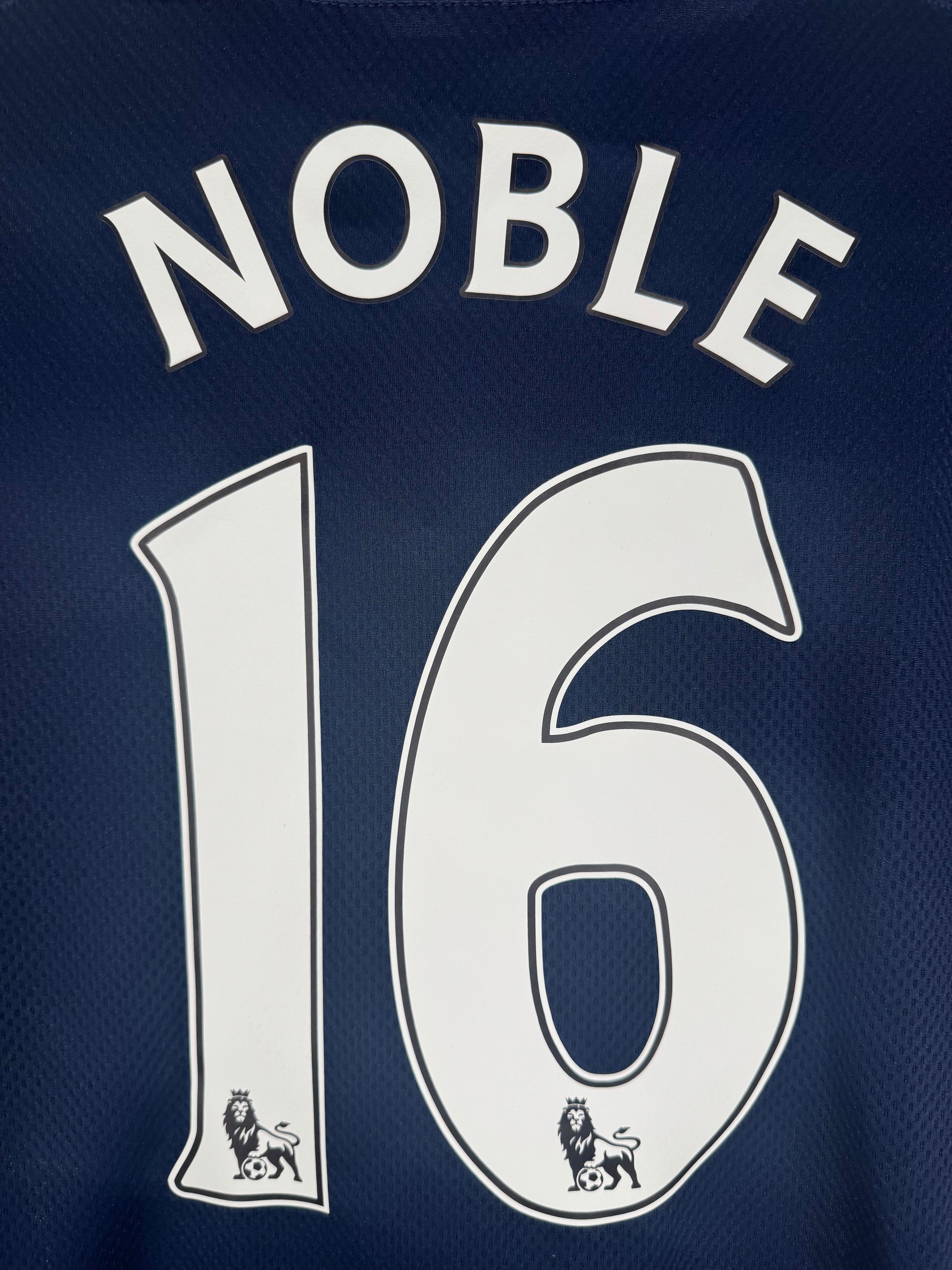 Zoom sur le nom NOBLE et le numéro 16 en typographie officielle Premier League.