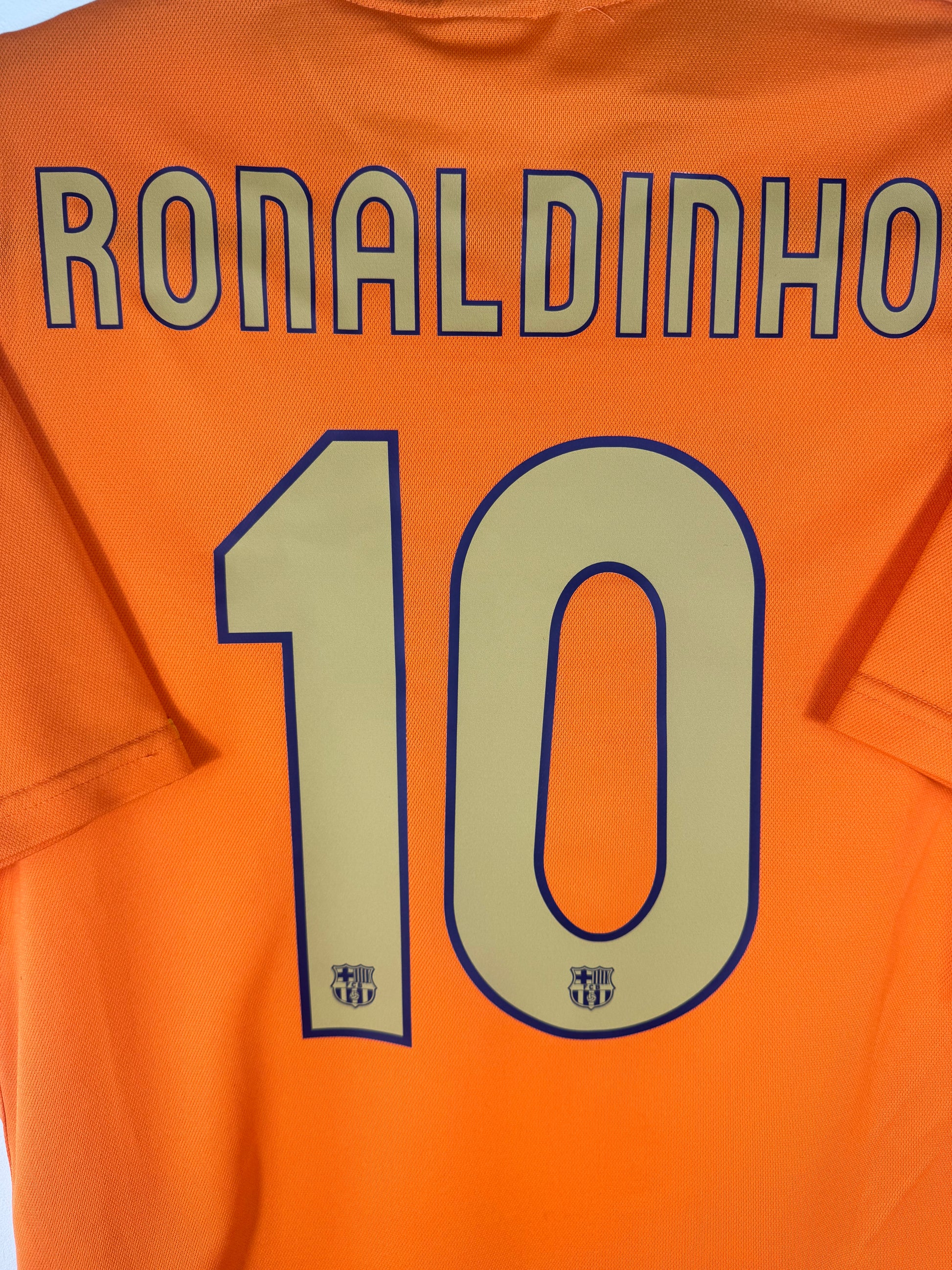 Zoom sur le nom RONALDINHO et le numéro 10 jaune avec logo du club intégré dans la typographie.