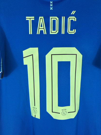 Zoom sur le nom TADIĆ et le numéro 10 vert néon typographie officielle.