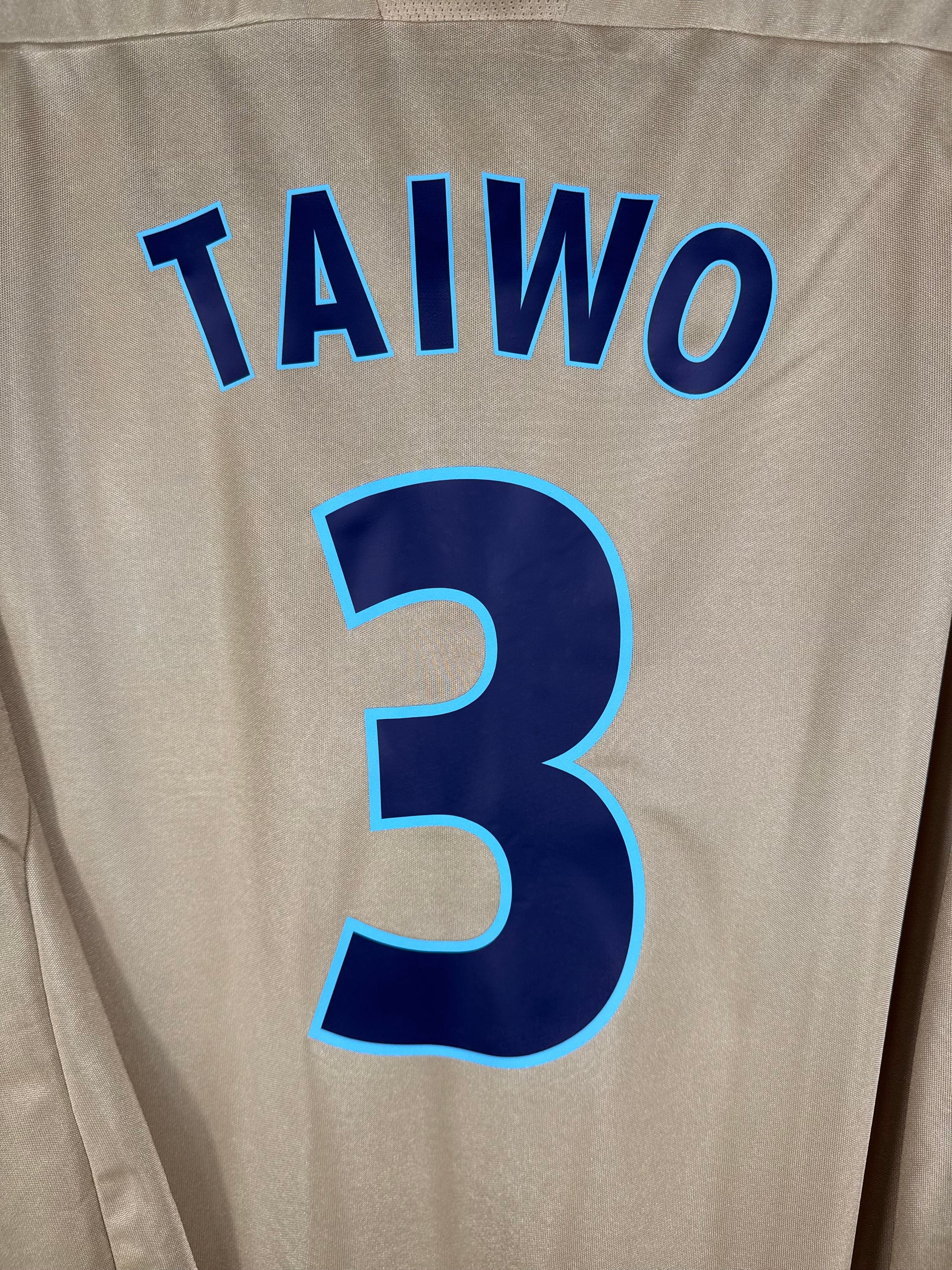 Zoom sur le nom TAIWO et le numéro 3 bleu avec contour liseré bleu clair.