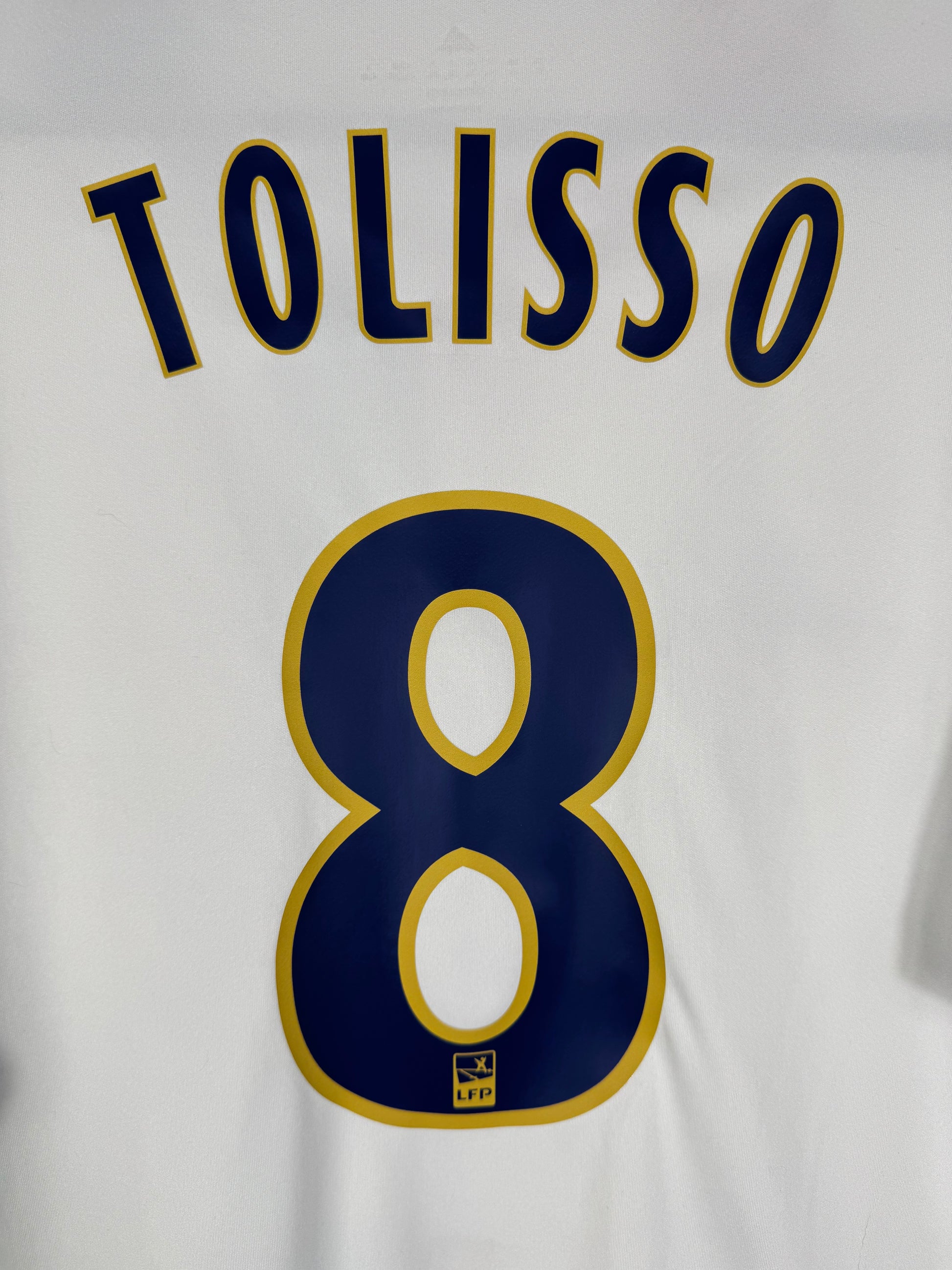Zoom sur le nom TOLISSO et le numéro 8 bleu avec logo du club intégré, police officielle OL 2017.
